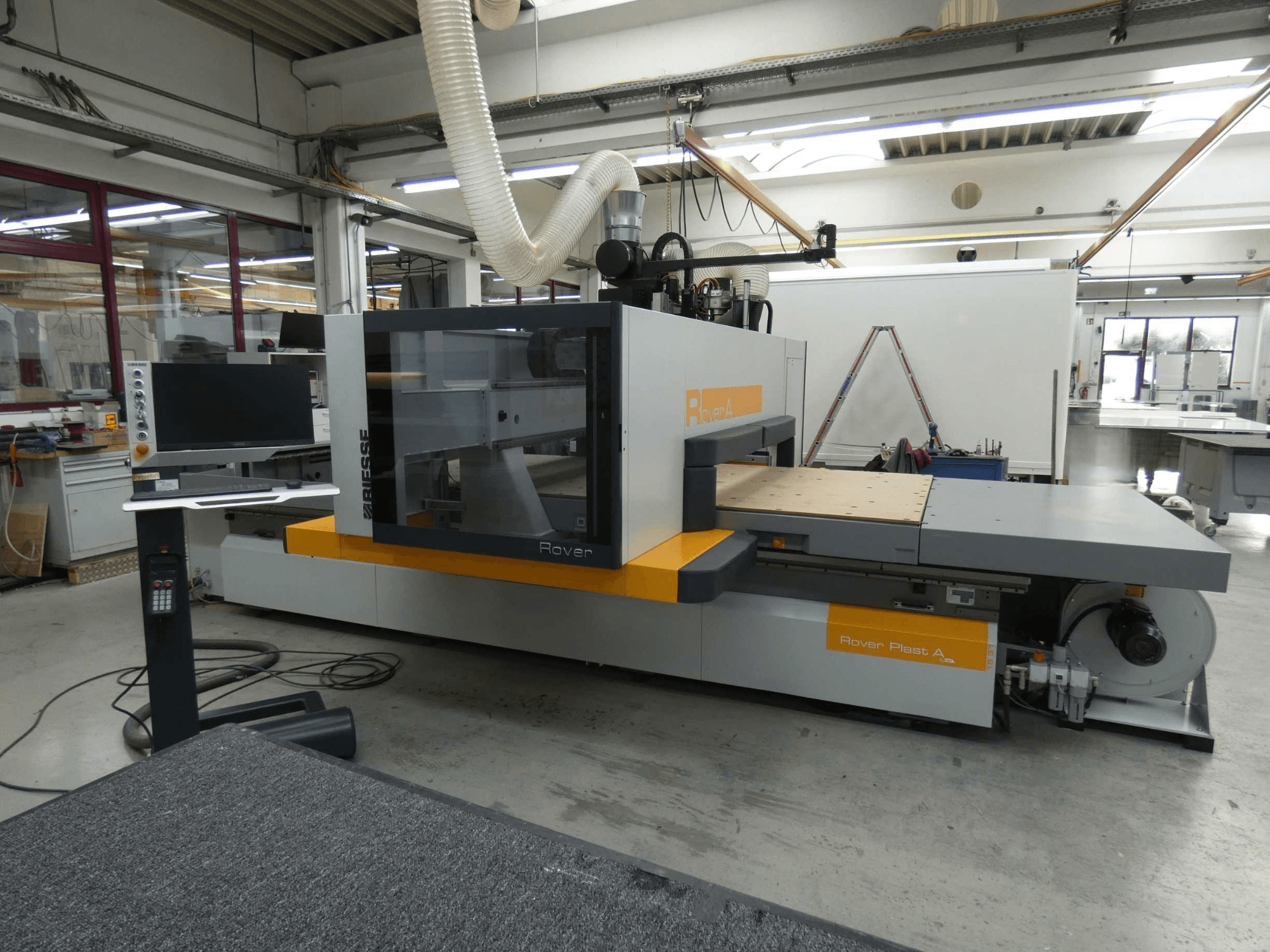 Vista frontale del centro di lavorazione del legno CNC BIESSE ROVER PLAST A FT 1224, con monitor e pannello di comando visibili.