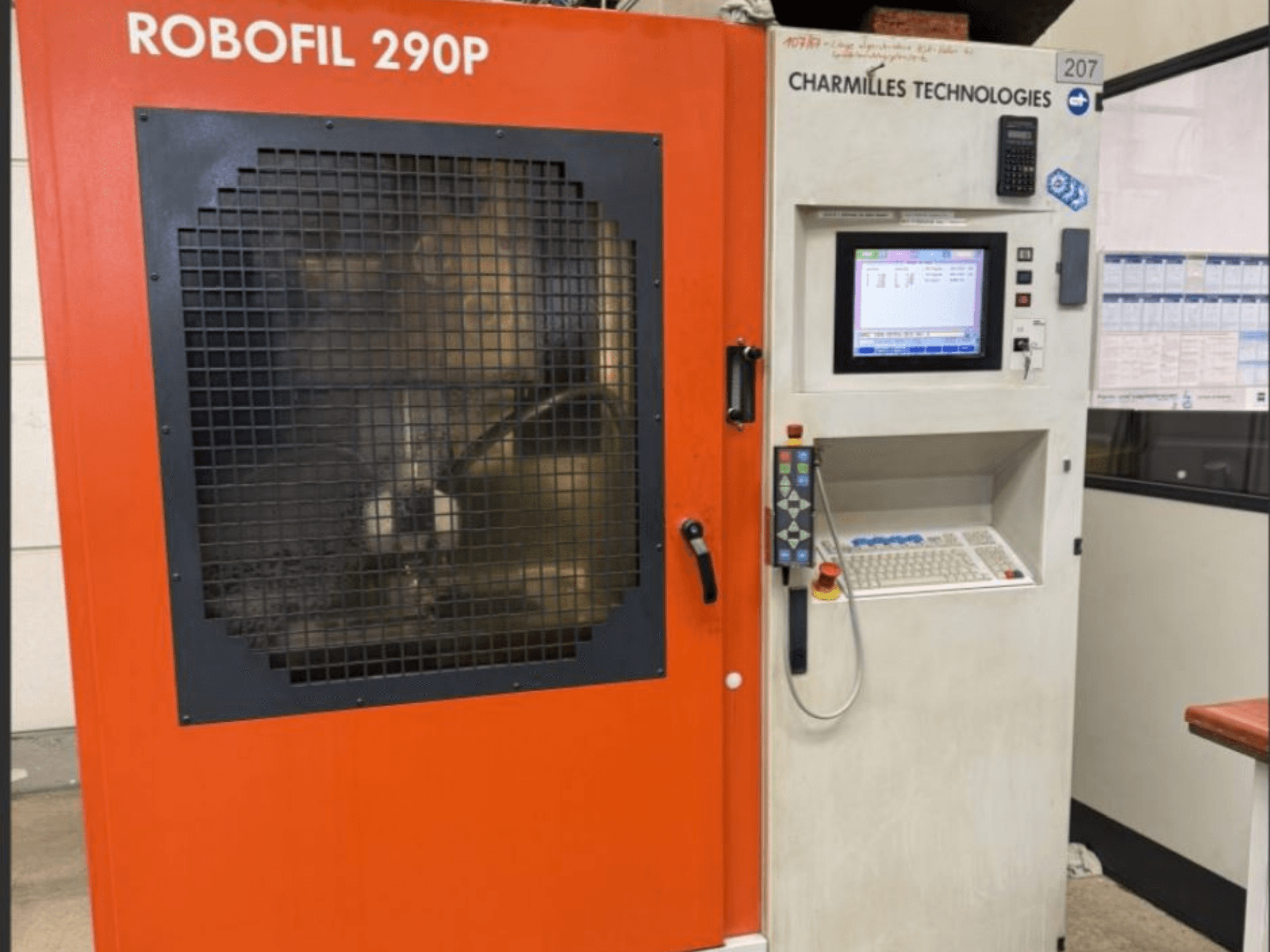 Vista frontale della macchina per elettroerosione a filo CHARMILLES TECHNOLOGIES Robofil 290P con pannello di controllo e area di lavoro protetta da griglia.