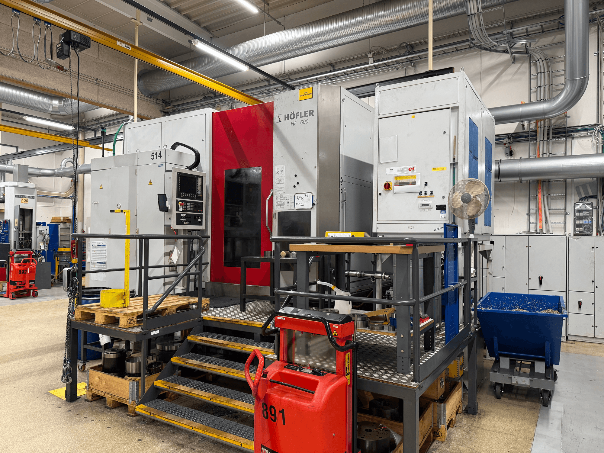 Macchina utensile HOFLER HF 600, vista laterale, con pannello di controllo, barriera di sicurezza gialla e ambiente circostante.