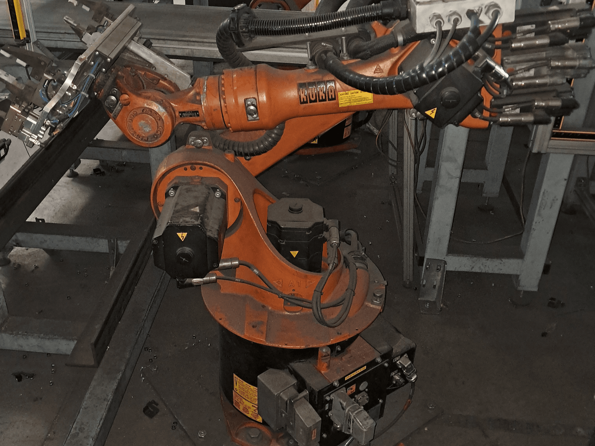 Il braccio robotico KUKA KR 16-2 visto dall'alto, con il corpo arancione, il motore e i componenti meccanici ben visibili.
