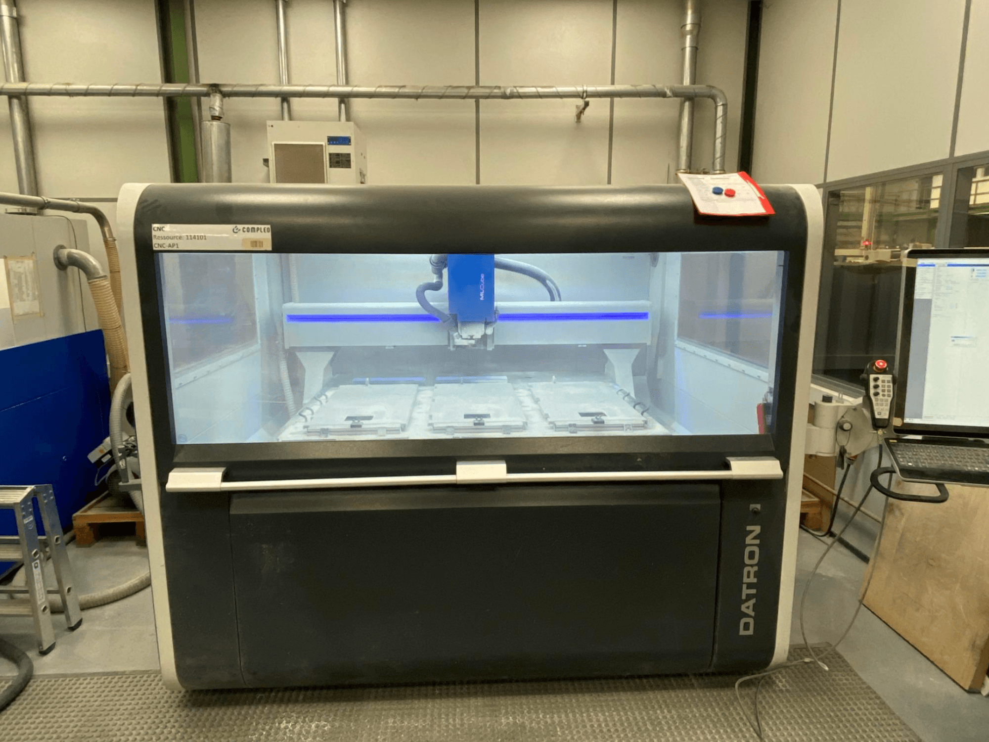 Centro di lavoro verticale Datron MLCube B, vista frontale, che mostra l'interno della macchina e il pannello di controllo.