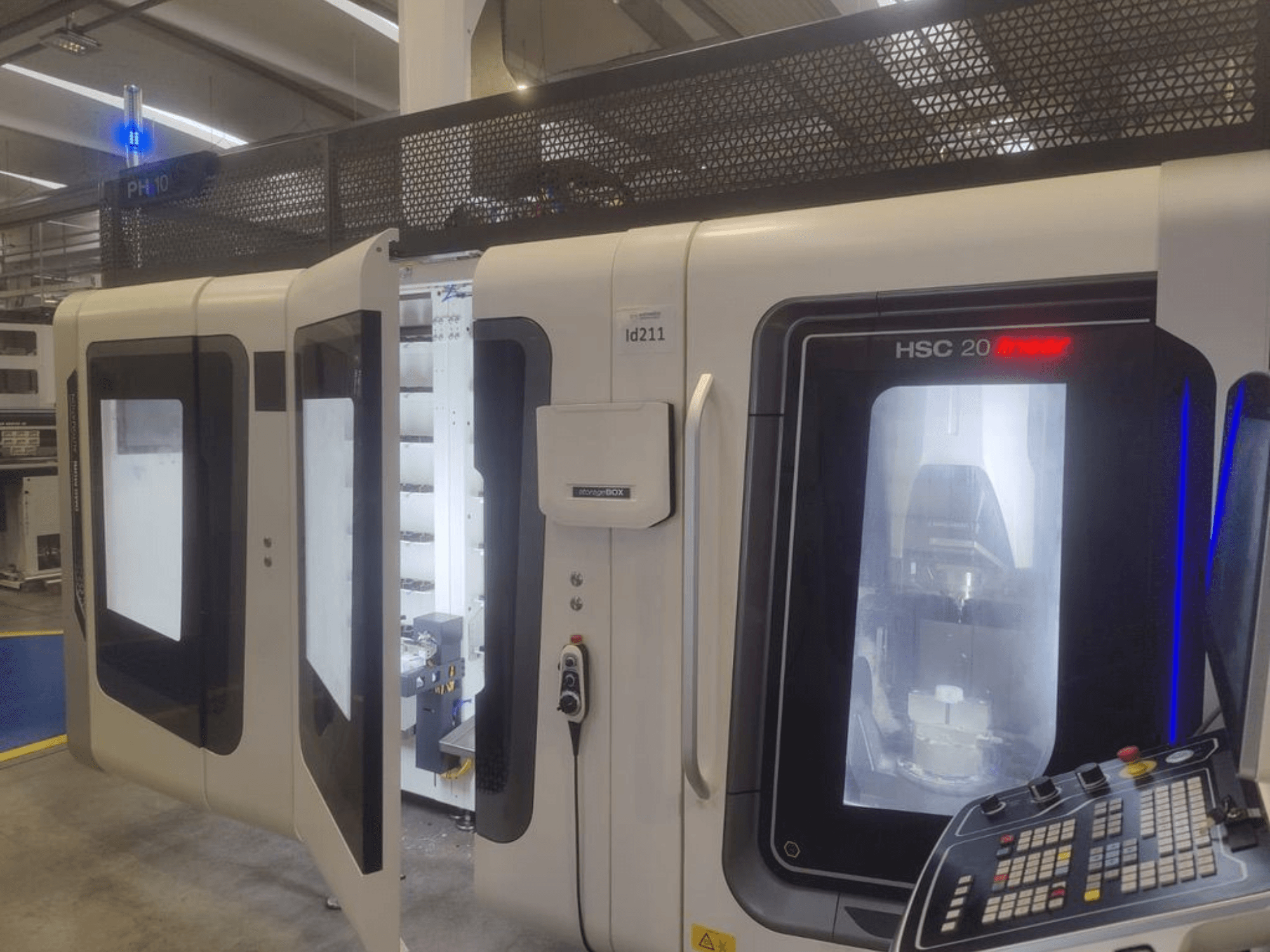 Centro di lavoro verticale DMG MORI HSC 20, vista frontale, con porte aperte che rivelano l'interno della lavorazione e il pannello di controllo.