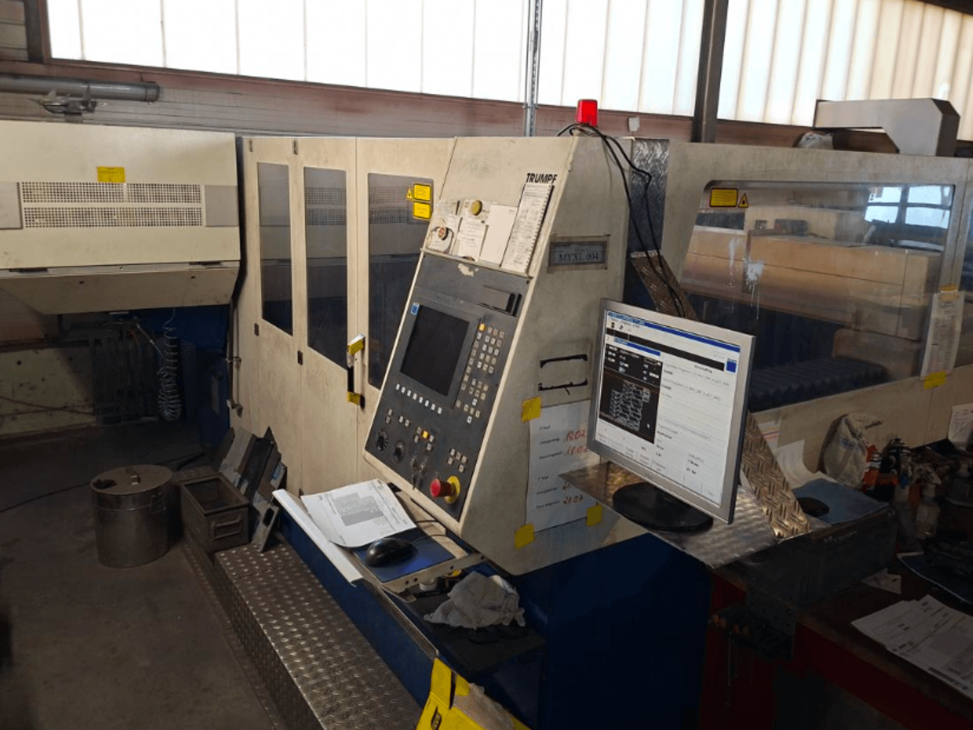 Macchina da taglio laser CO2 TRUMPF Trumatic L 4030, vista frontale che mostra il pannello di controllo e il monitor, con dettagli dell'area di lavoro visibili.