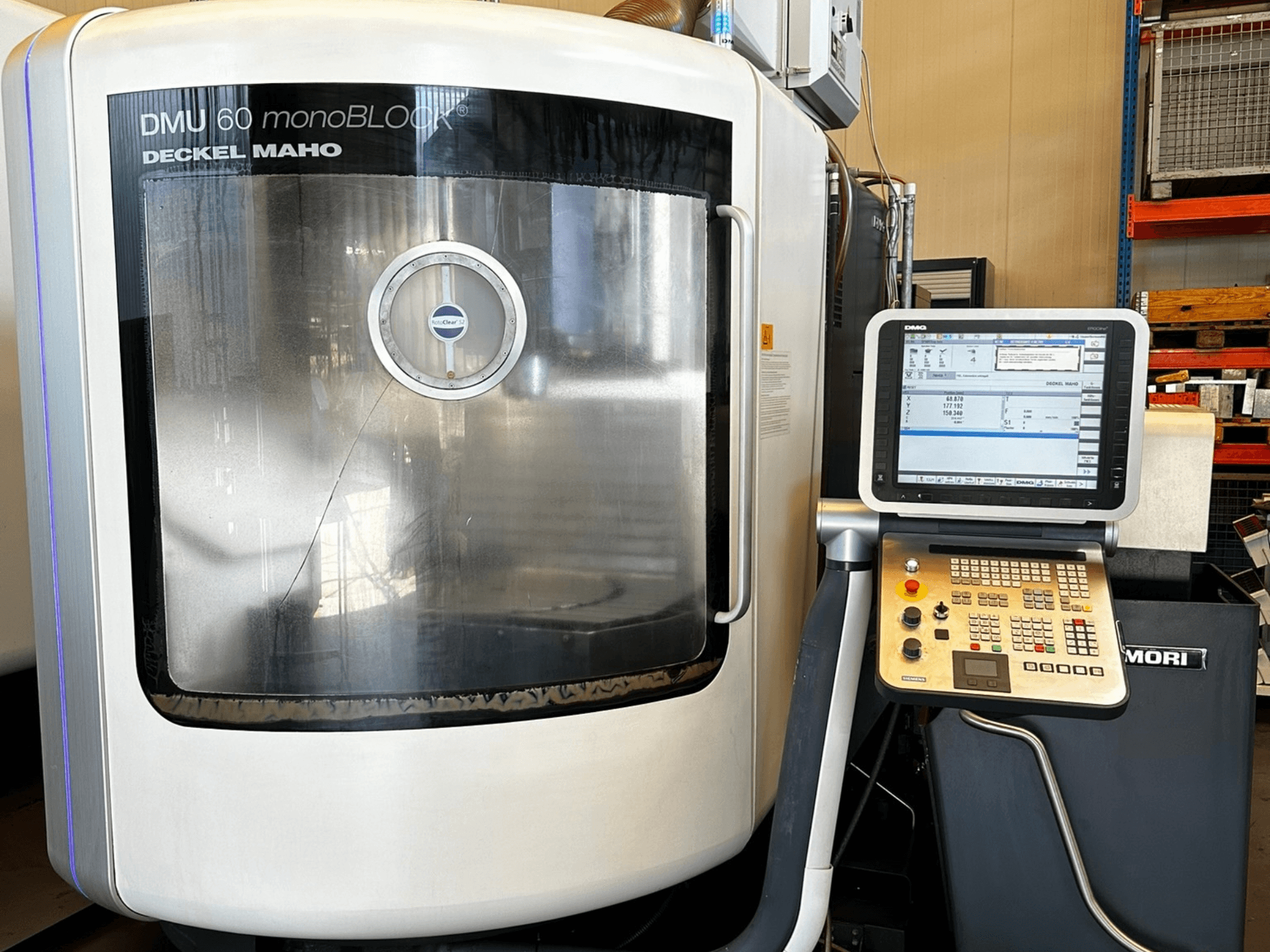 Centro di lavoro verticale DMG MORI DMU 60 monoBLOCK, vista frontale, con pannello di controllo touchscreen e finestra riflettente.