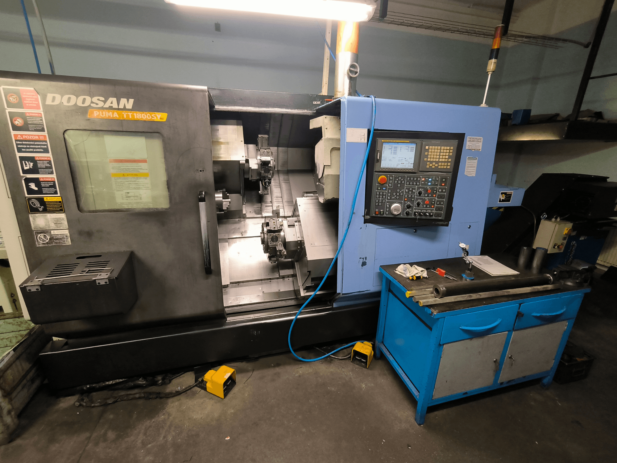 Tornio CNC Doosan Puma TT1800SY, vista frontale, con pannello di controllo, area di lavoro con utensili e componenti della macchina.