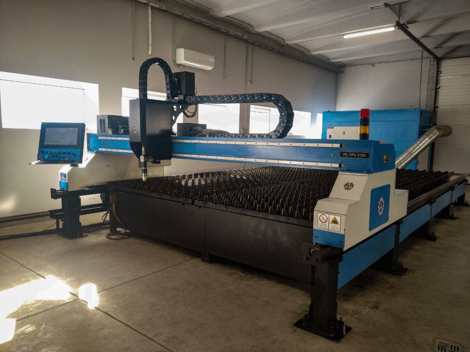 Macchina per il taglio al plasma INANMAK MEKOR PL-YPe 3100, vista frontale, con pannello di controllo e tavolo di taglio con punte metalliche rialzate.