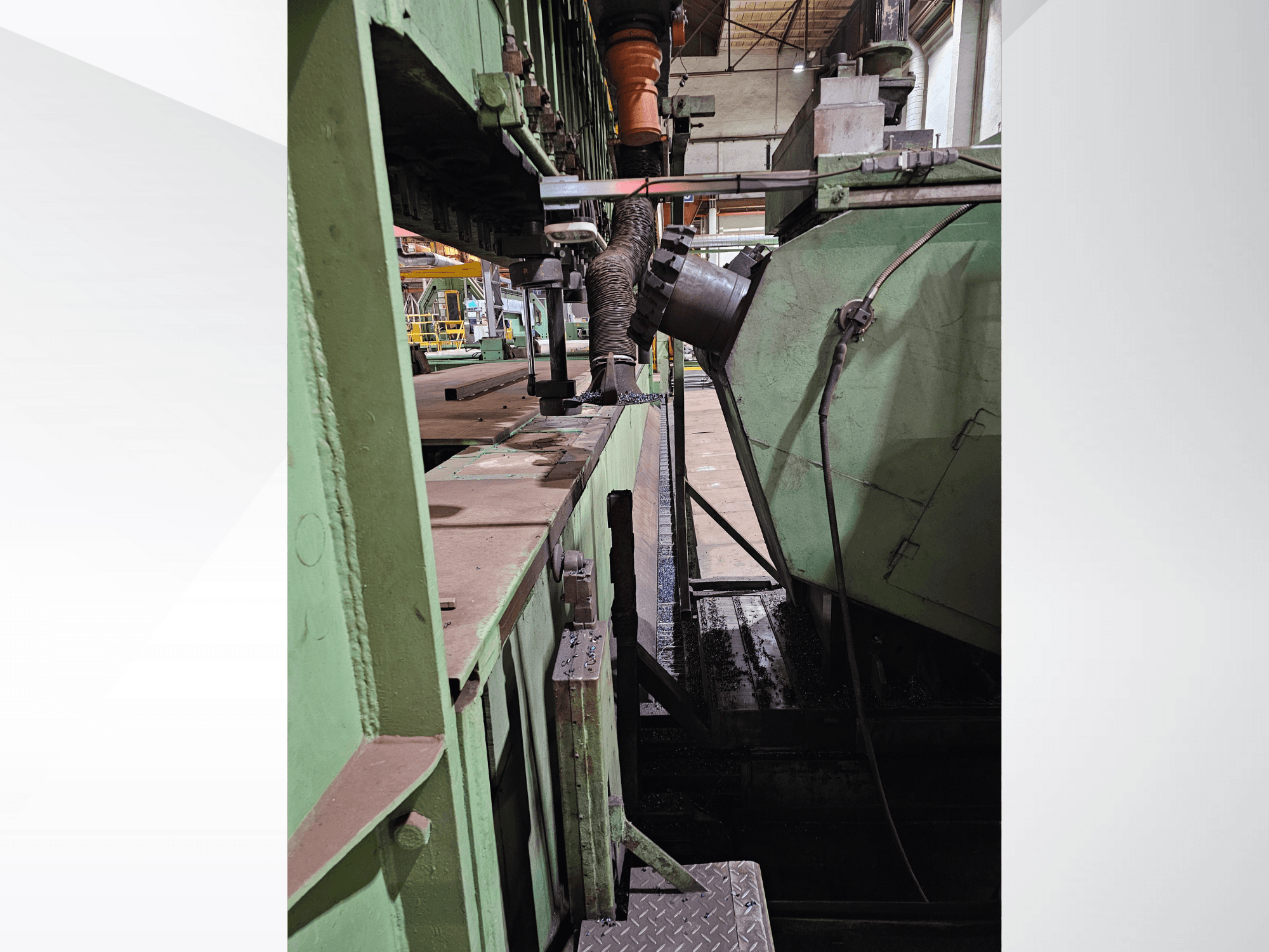 Macchinario industriale verde con vista laterale di una tramoggia e di un meccanismo di alimentazione, con componenti metallici e una piattaforma.