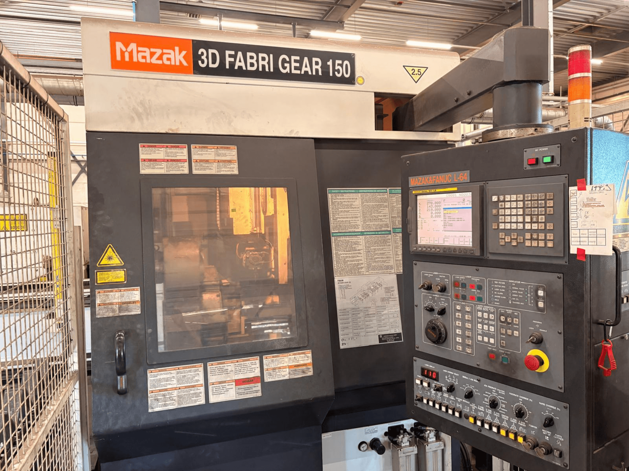 Macchina per il taglio di tubi Mazak 3D Fabri Gear 150, vista frontale che mostra il pannello di controllo, le etichette di sicurezza e l'interfaccia operativa.