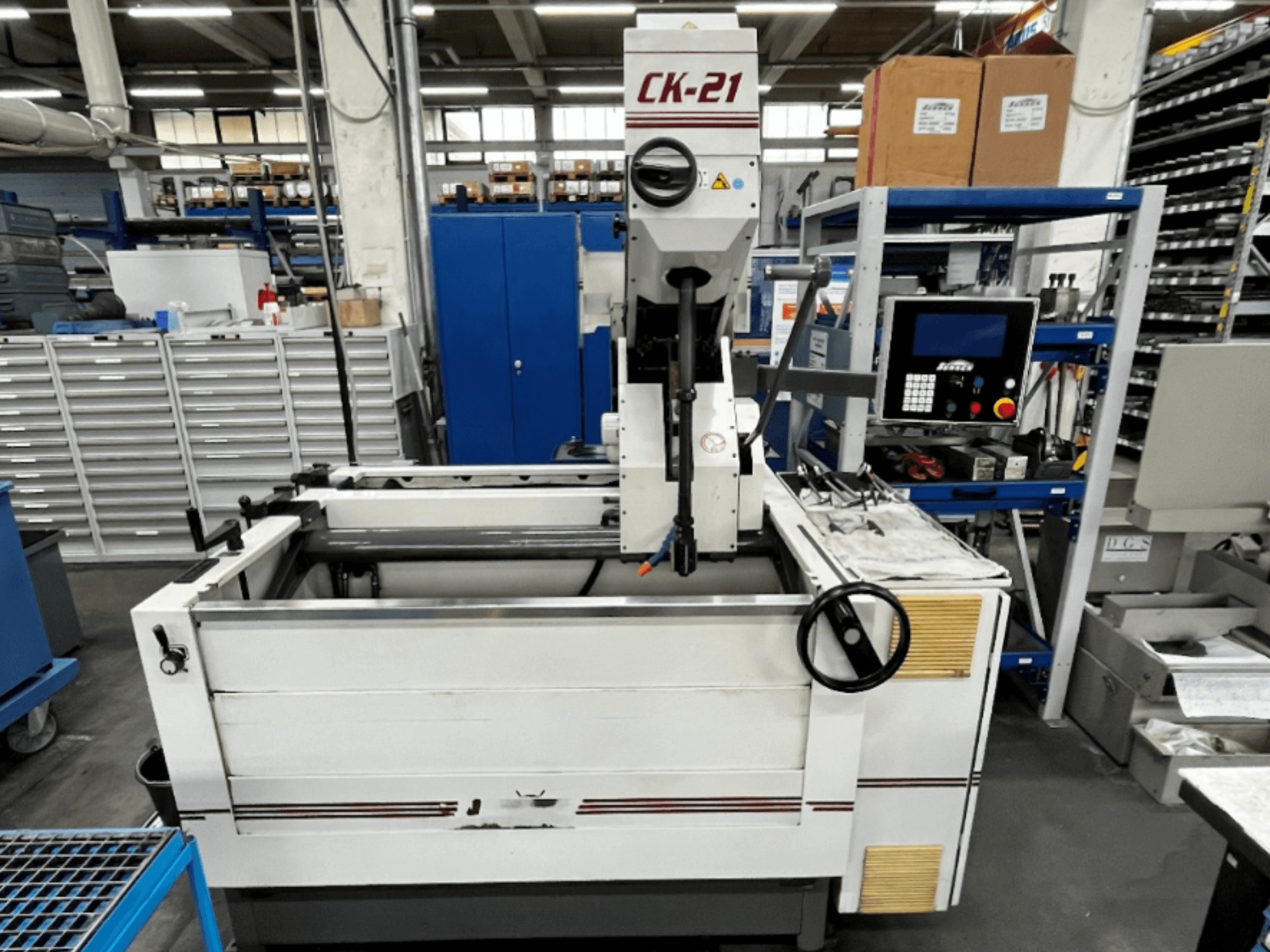 Macchina di levigatura verticale Sunnen CK-21-CC in vista frontale, con comandi, area di levigatura e attrezzature di supporto sullo sfondo.