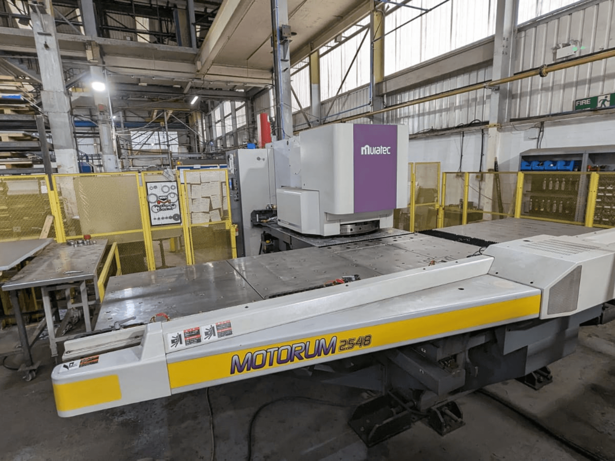 Punzonatrice CNC Muratec MOTORUM 2548, vista frontale che mostra il pannello di controllo e il piano di lavoro in un ambiente industriale.