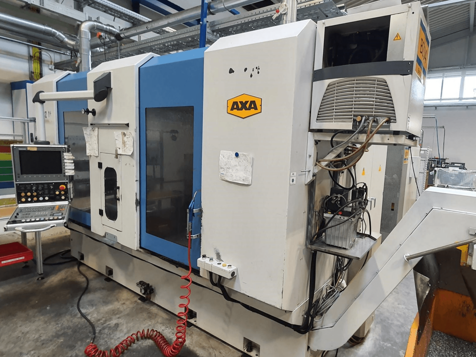 Centro di lavorazione verticale AXA DBZ, vista frontale, con pannello di controllo e dettaglio visibile del sistema di raffreddamento.