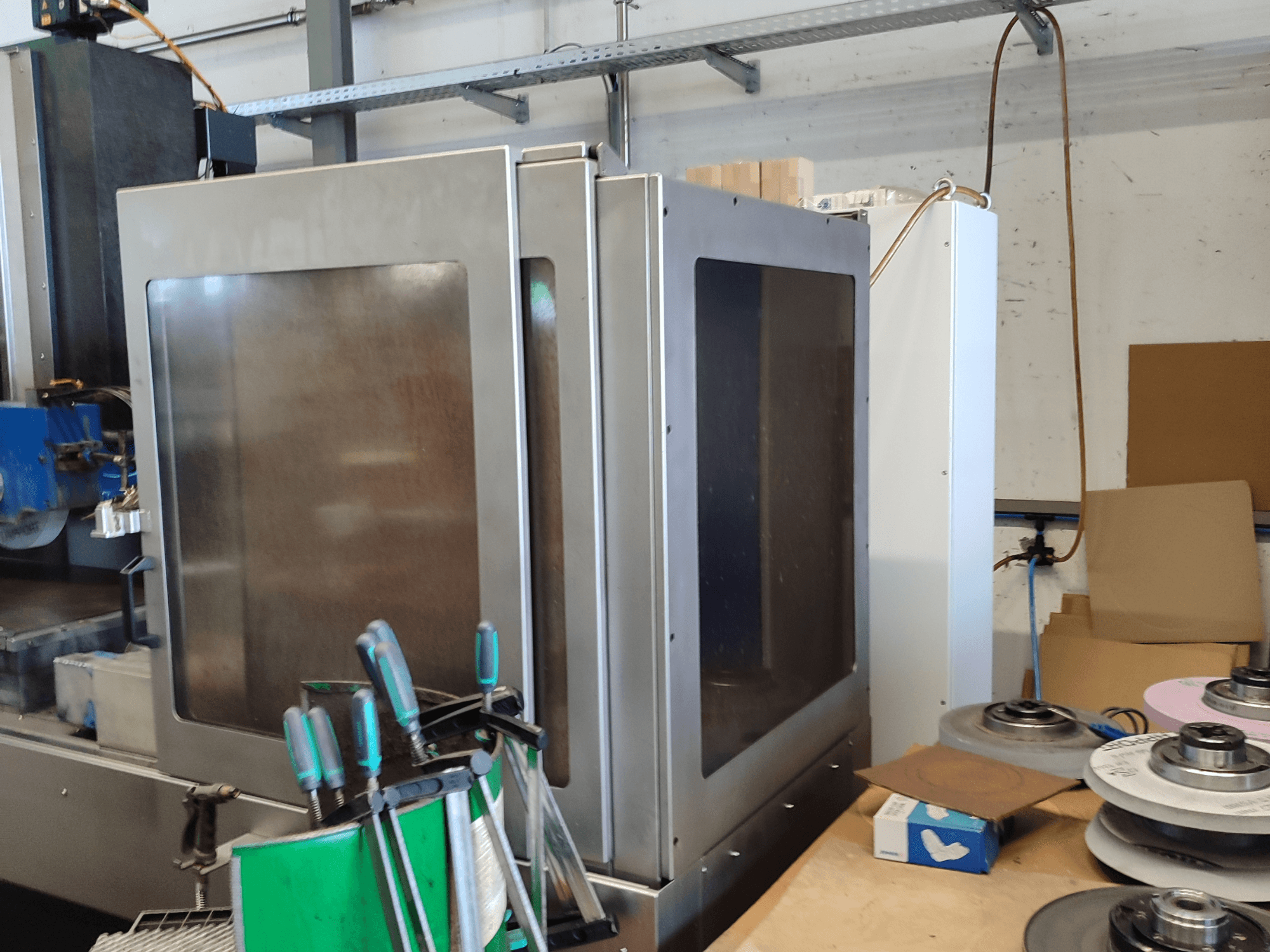 Rettificatrice per superfici HEINZ STÖCKEL FD 1560 NC-T, vista laterale che mostra la carcassa metallica e i componenti di rettifica in un'officina.