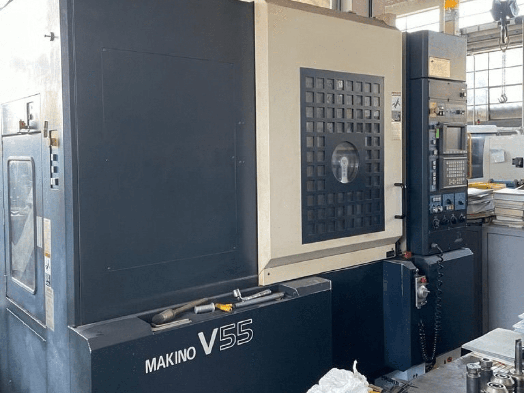 Centro di lavorazione verticale Makino V55-A15, vista frontale che mostra il pannello di controllo, la struttura robusta e la configurazione dell'area di lavoro.