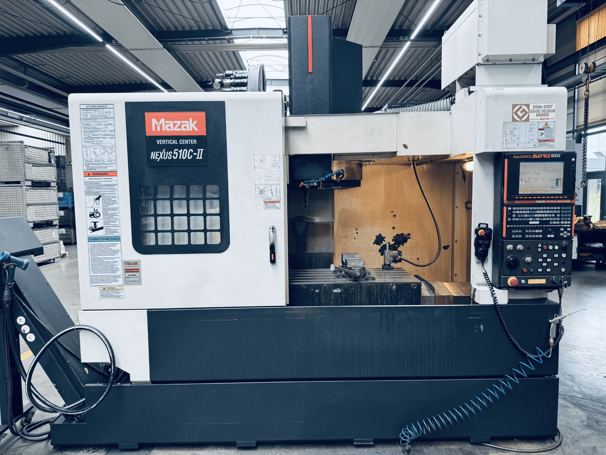 Centro verticale Mazak Nexus 510C-II, vista frontale, che mostra il pannello di controllo, l'area di lavoro e le caratteristiche operative in un ambiente di officina.