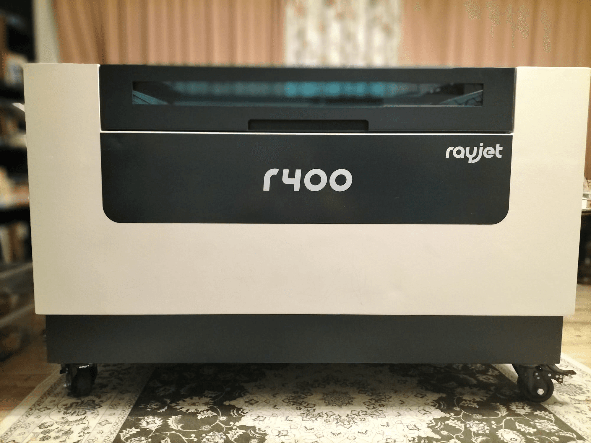 Vista frontale della macchina per incisione laser Trotec Rayjet R400, che mostra il suo design elegante e il suo marchio chiaro.