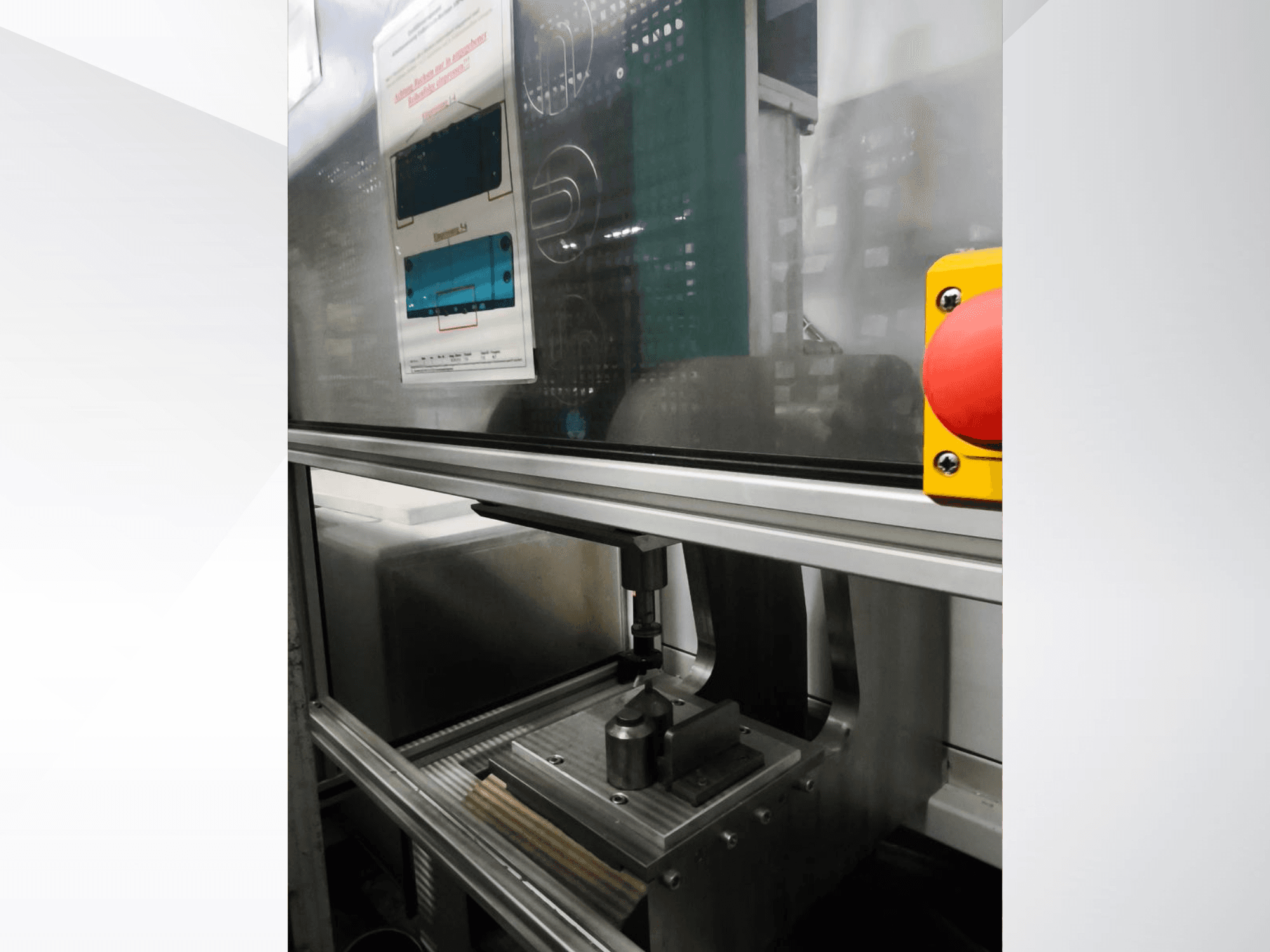 Vista frontale della macchina utensile EMS Automation Buchsenpresse, che mostra il meccanismo di pressatura e il pulsante di sicurezza.