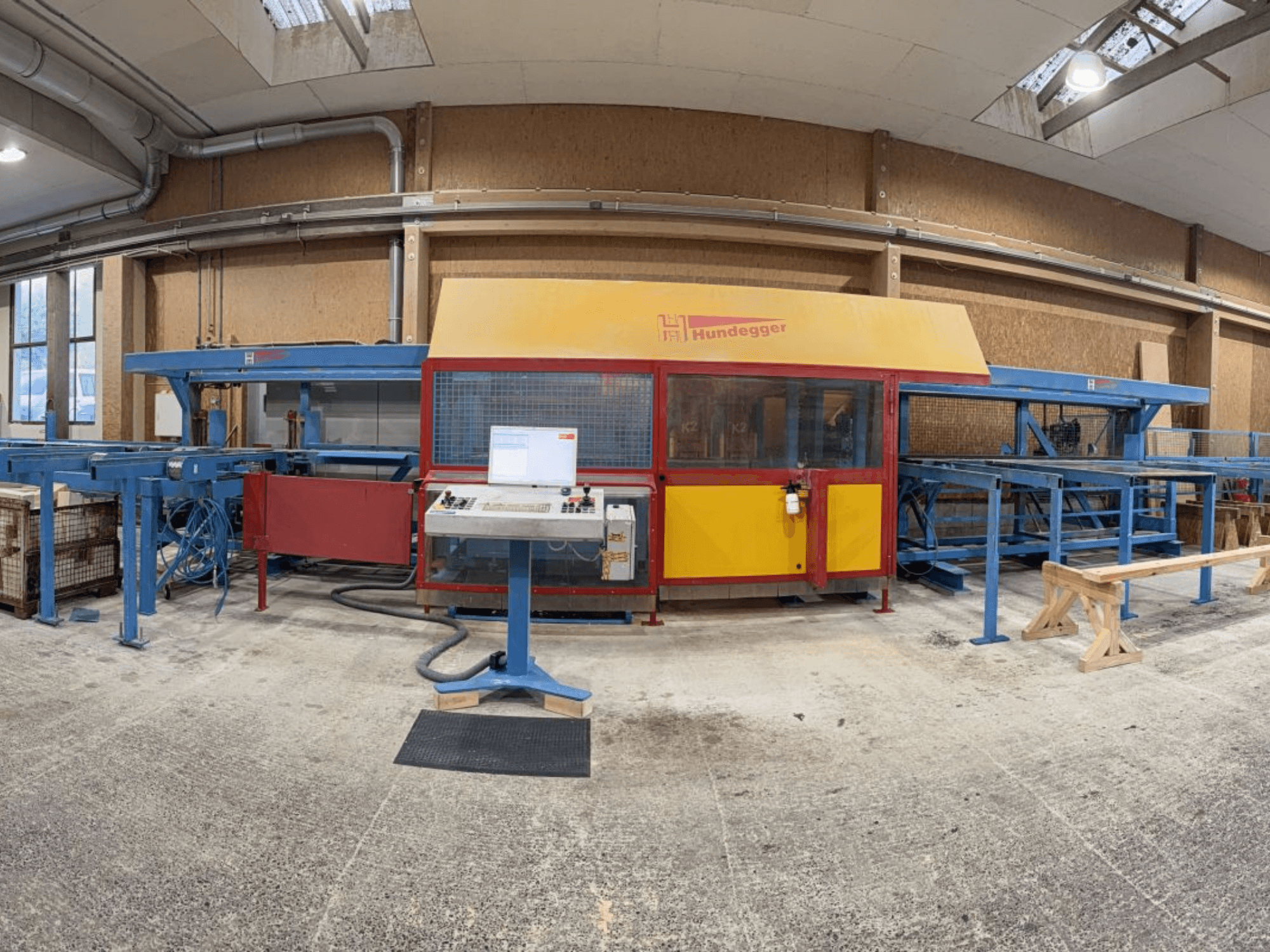 Vista frontale della linea di produzione di legno completa HUNDEGGER K2-4-450, con pannello di controllo e sistema di trasporto.