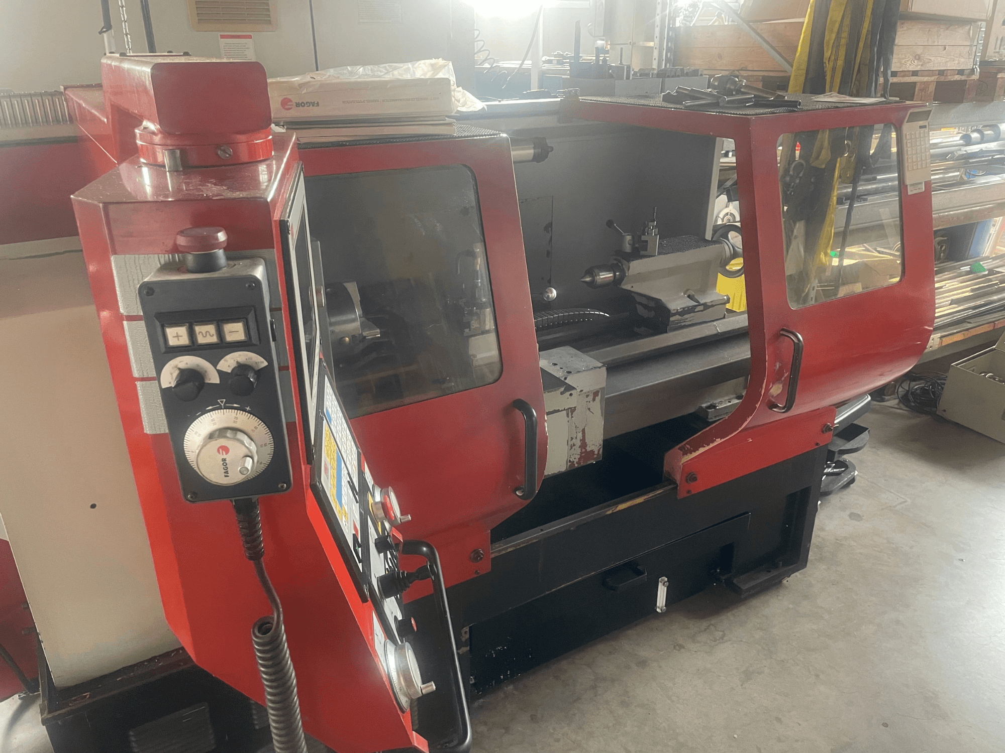 Tornio orizzontale EMCO EMCOMAT 200X1000, vista laterale, con comandi, cabina vetrata e configurazione del tornio.