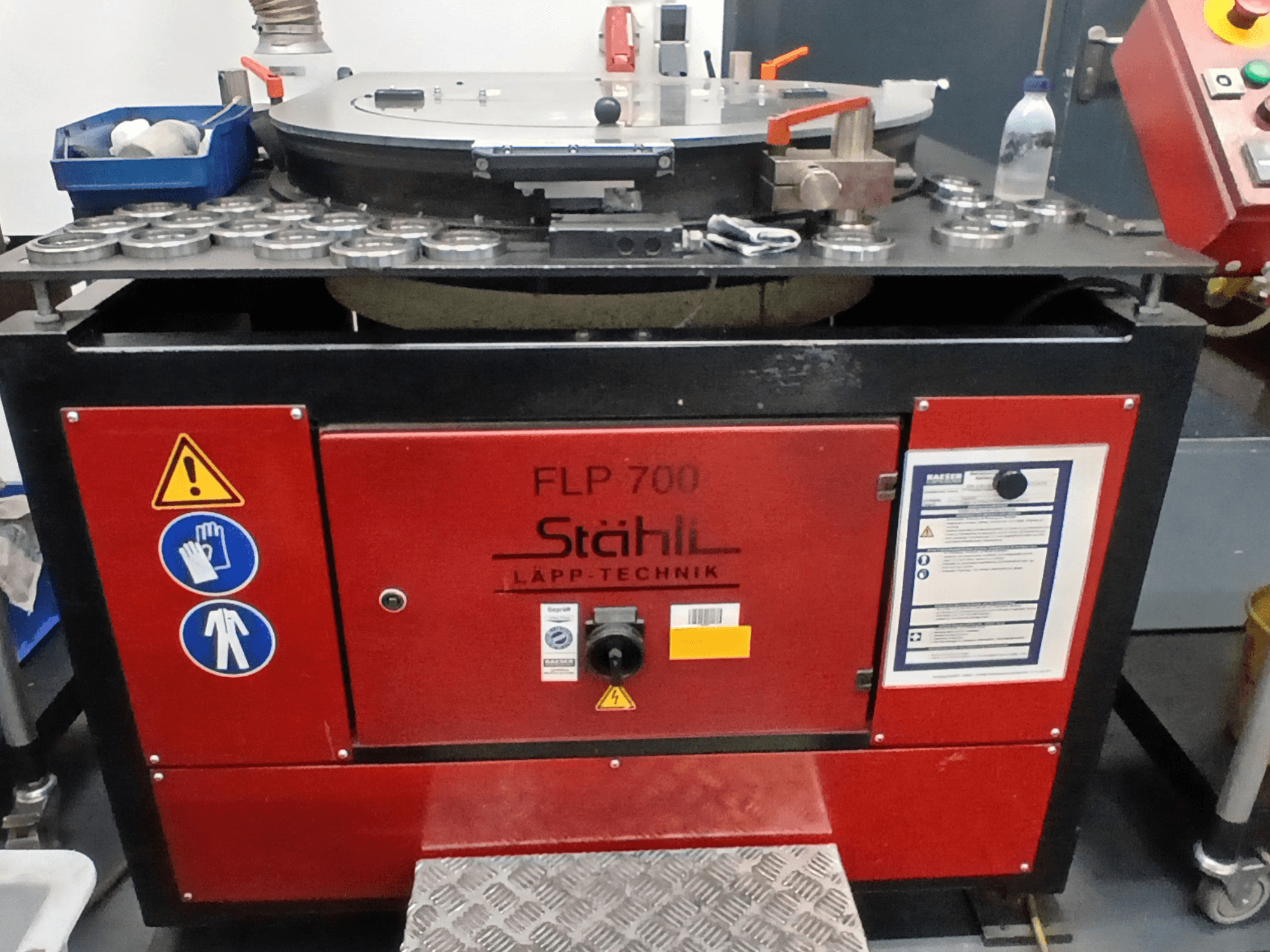 Macchina utensile STAHLI FLP 700, vista frontale, con comandi operativi, avvisi di sicurezza e componenti su una superficie metallica.