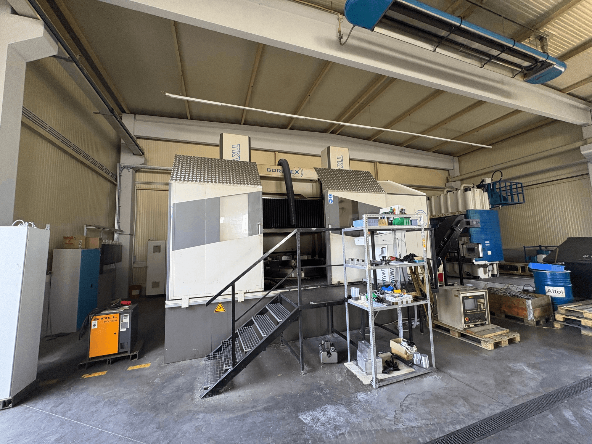 Set di lavorazione industriale con macchina GORAT X, vista laterale; include utensili, pannello di controllo e attrezzature su scaffali.