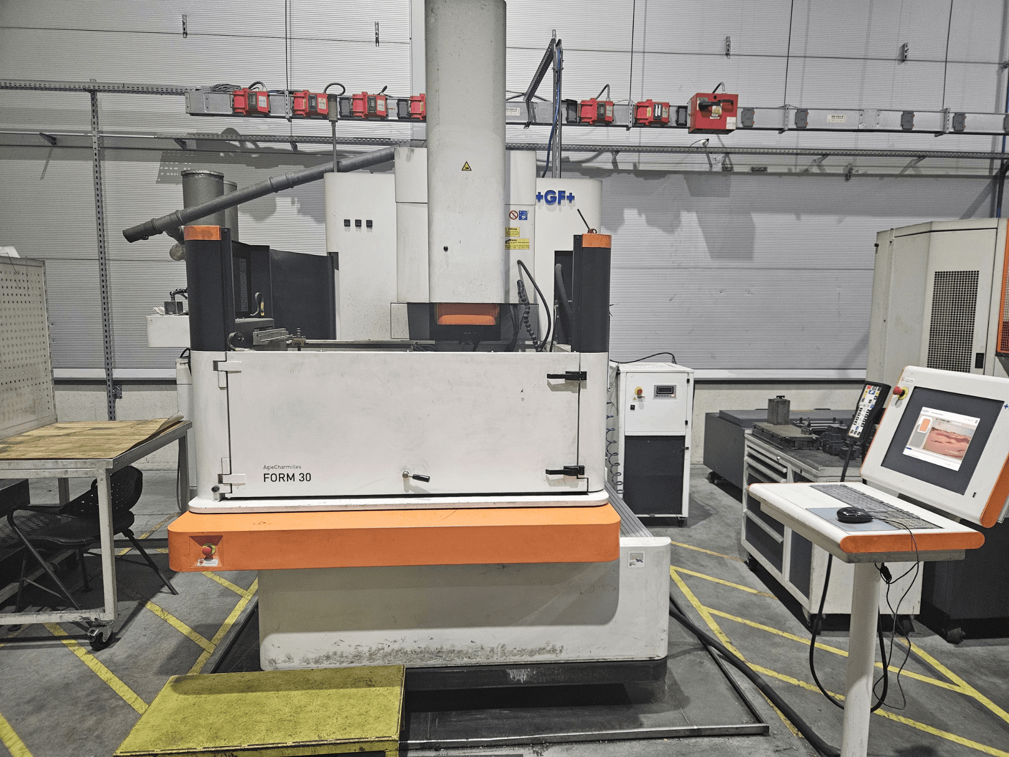 Macchina ApeqChemicals FORM 30 in un'officina, vista frontale con pannello di controllo e tavolo di lavoro a lato.