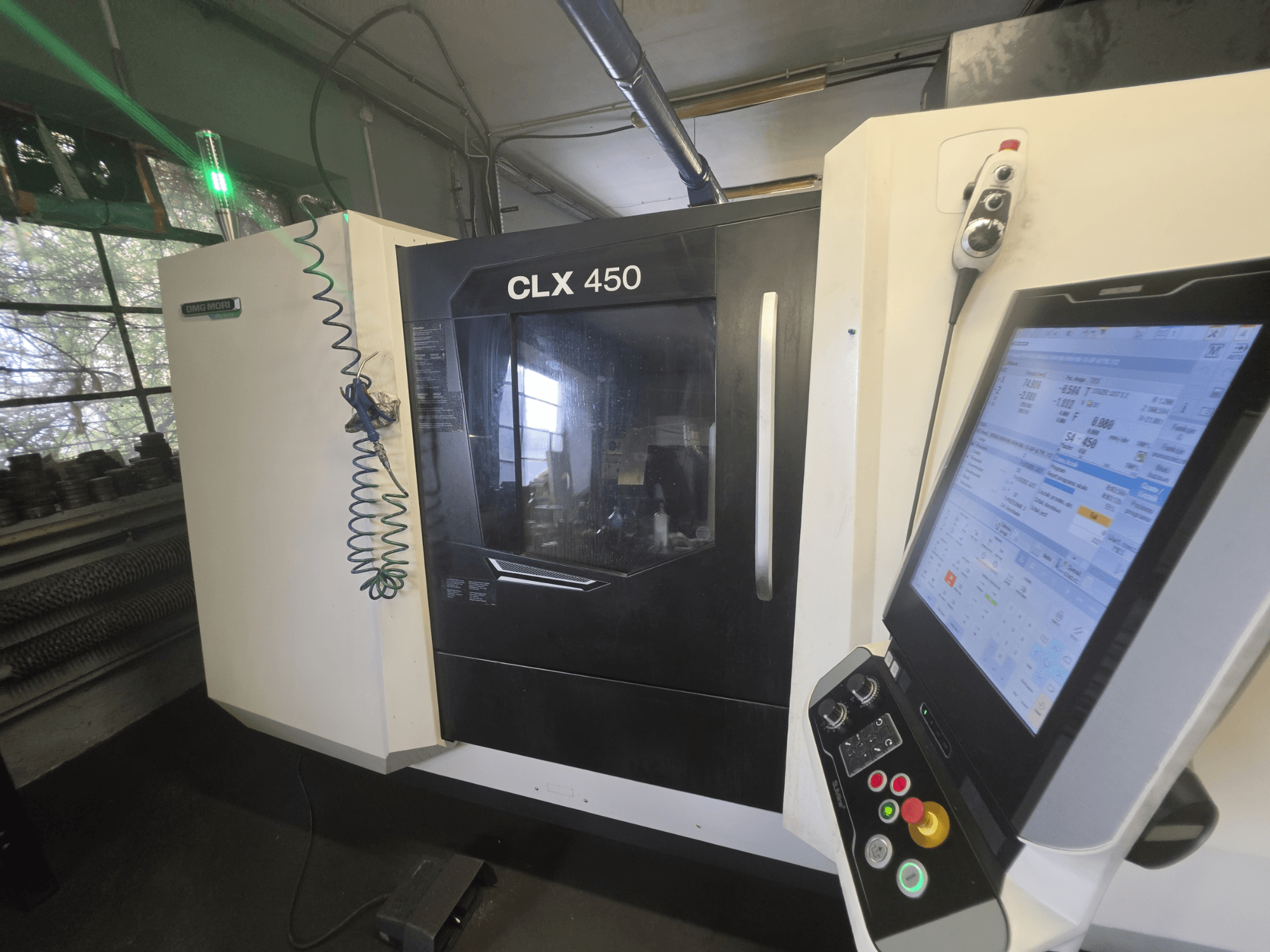 Tornio orizzontale DMG MORI CLX 450 V3, vista frontale con pannello di controllo e monitor che visualizza i dati operativi.
