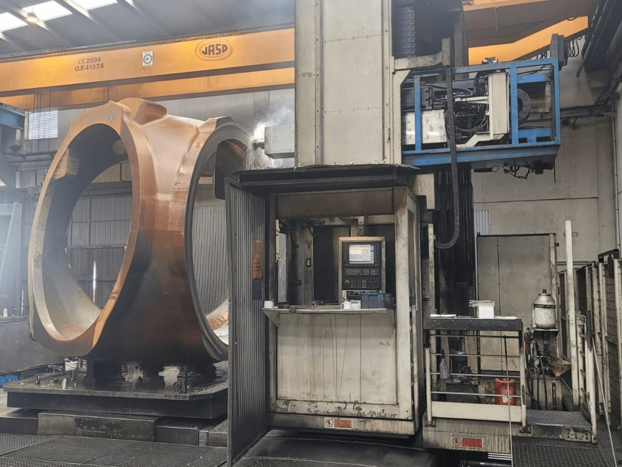 Centro di fresatura e tornitura PAMA Speedram 1000, vista laterale, con un pezzo di grandi dimensioni e il pannello di controllo in un ambiente industriale.