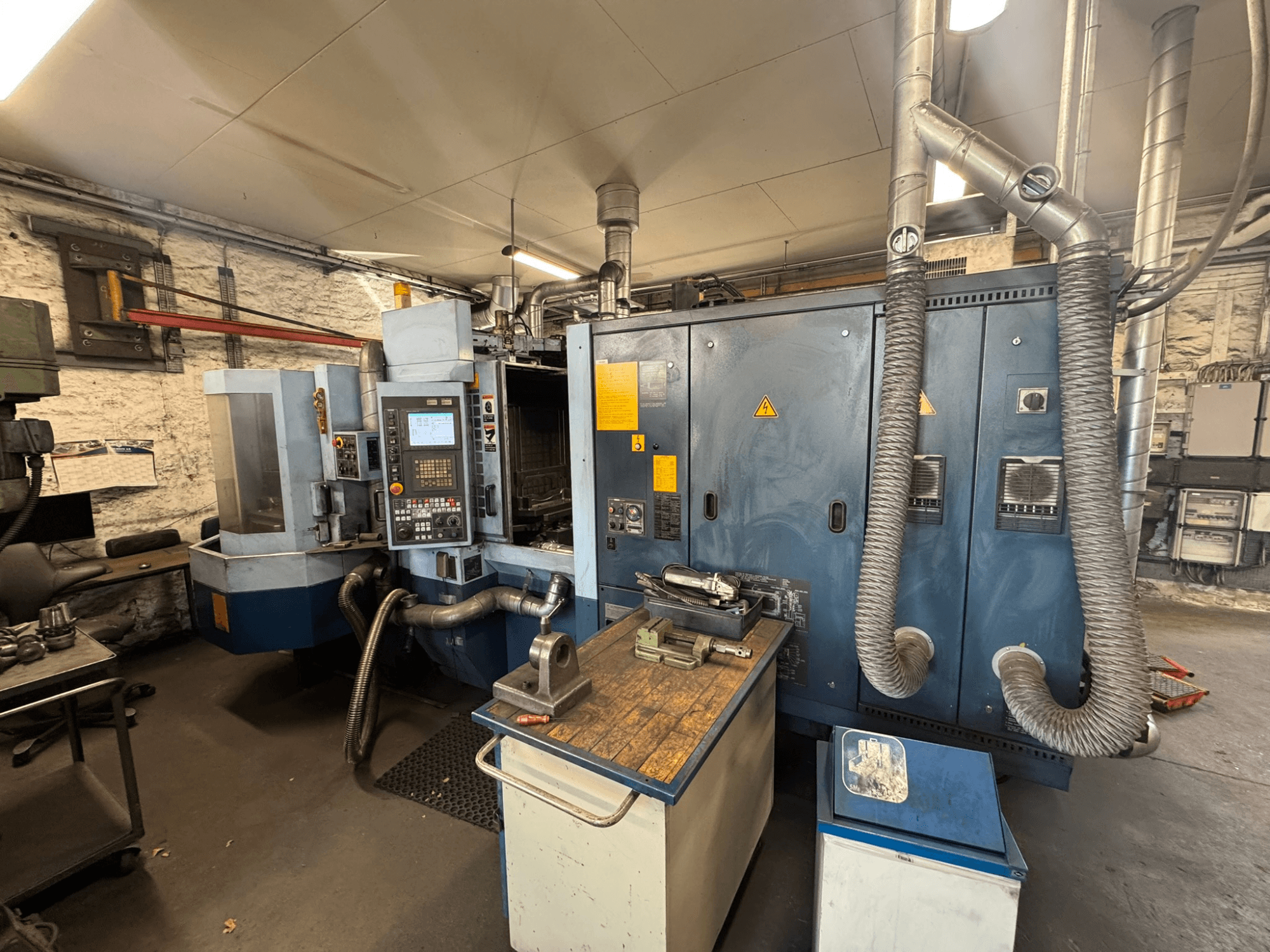 Centro di lavorazione orizzontale Matsuura H.PLUS-300 in un'officina, vista frontale, con pannello di controllo e piano di lavoro.