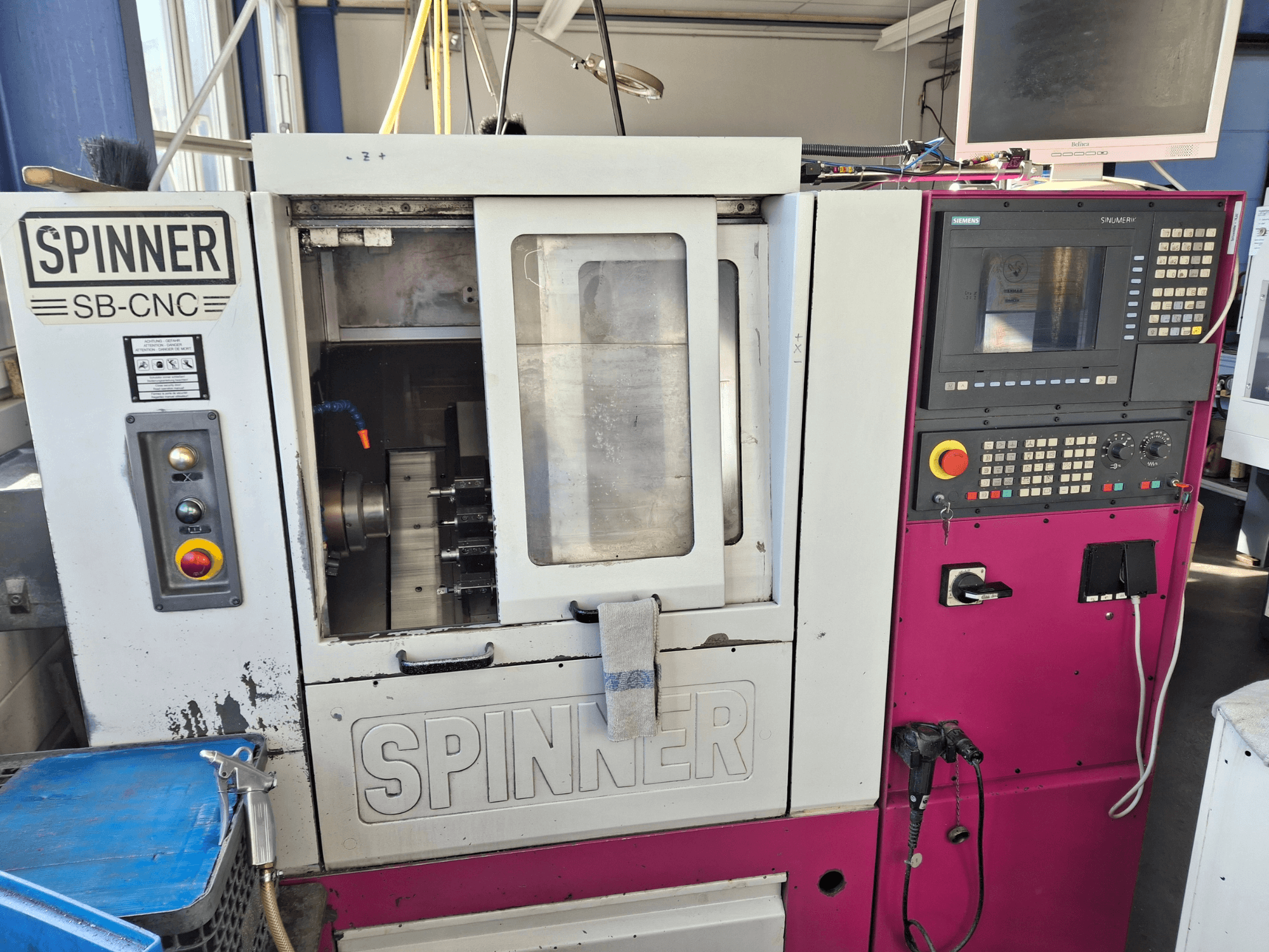 Tornio orizzontale SPINNER SB-CNC, vista frontale con pannello di controllo, portautensili e indicatori di funzionamento.