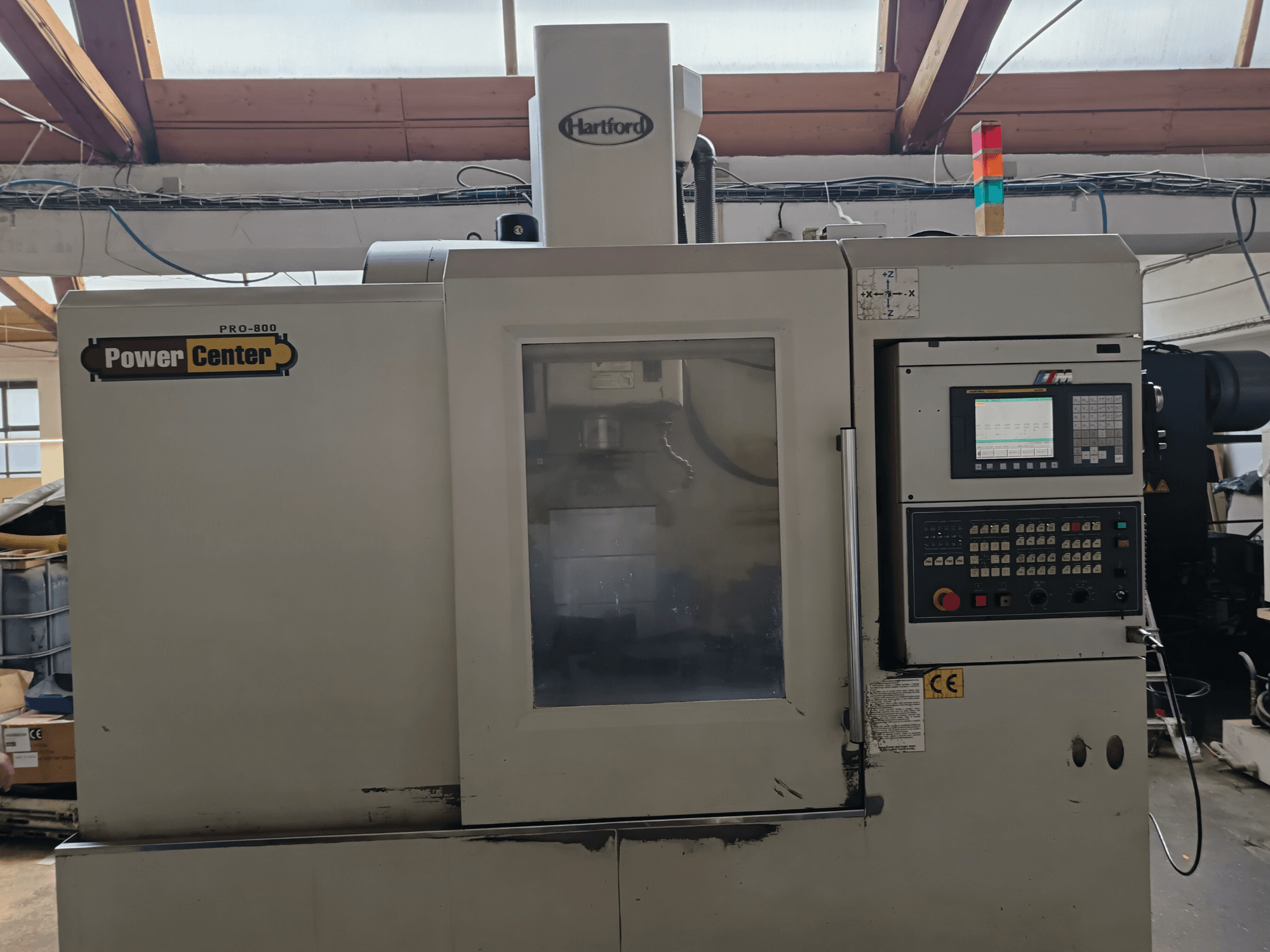 Centro di lavorazione verticale HARTFORD PRO-800A, vista frontale, con pannello di controllo e pannello in vetro che consente la visibilità interna.