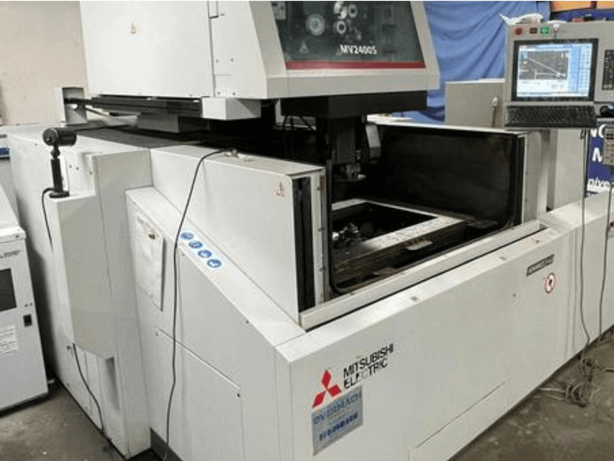 Macchina per elettroerosione a filo Mitsubishi Electric MV2400S, vista frontale, con pannello di controllo e area di lavoro aperta.