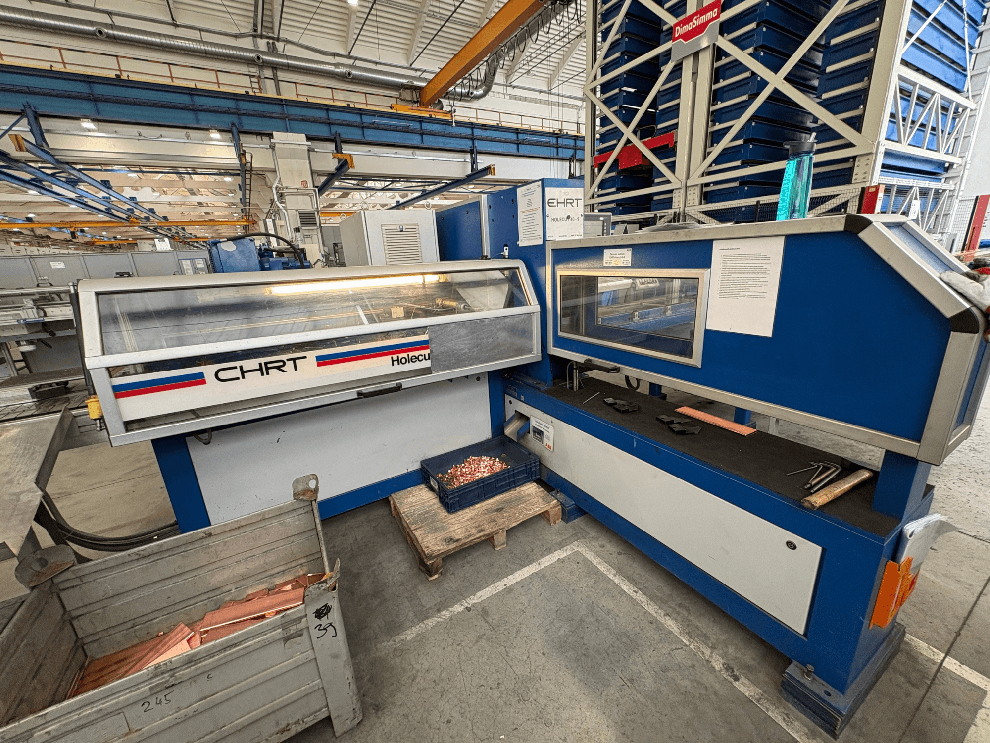 Punzonatrice CNC EHRT Holecut 40-9, vista frontale, con pannello di controllo, contenitore di metallo e lastre di rame nelle vicinanze.