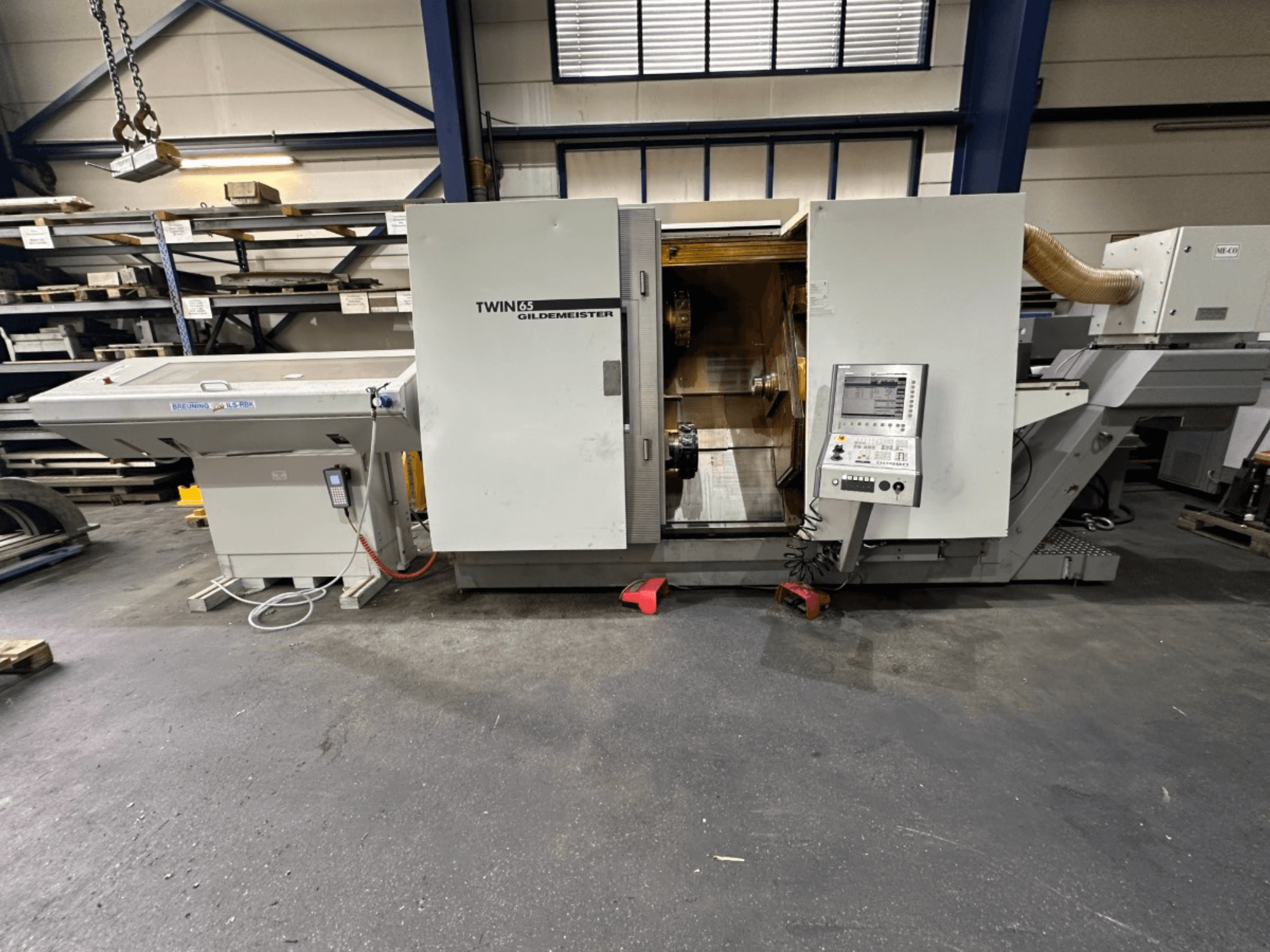 Tornio orizzontale Gildemeister TWIN 65, vista frontale; presenta un pannello di controllo e un interno visibile per la lavorazione dei pezzi.