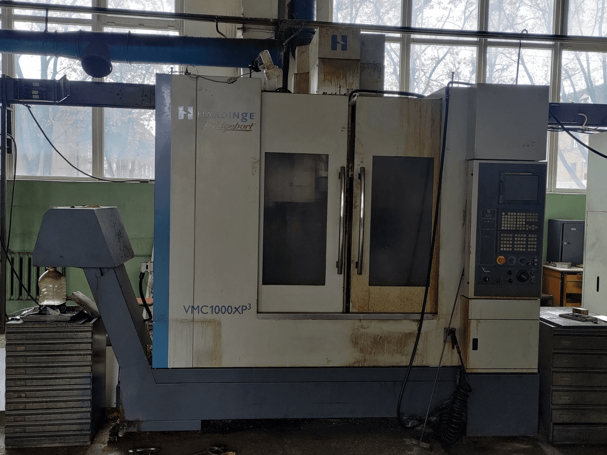Centro di lavorazione verticale Bridgeport VMC1000 XP3 visto frontalmente, con il pannello di controllo e lievi segni di usura.