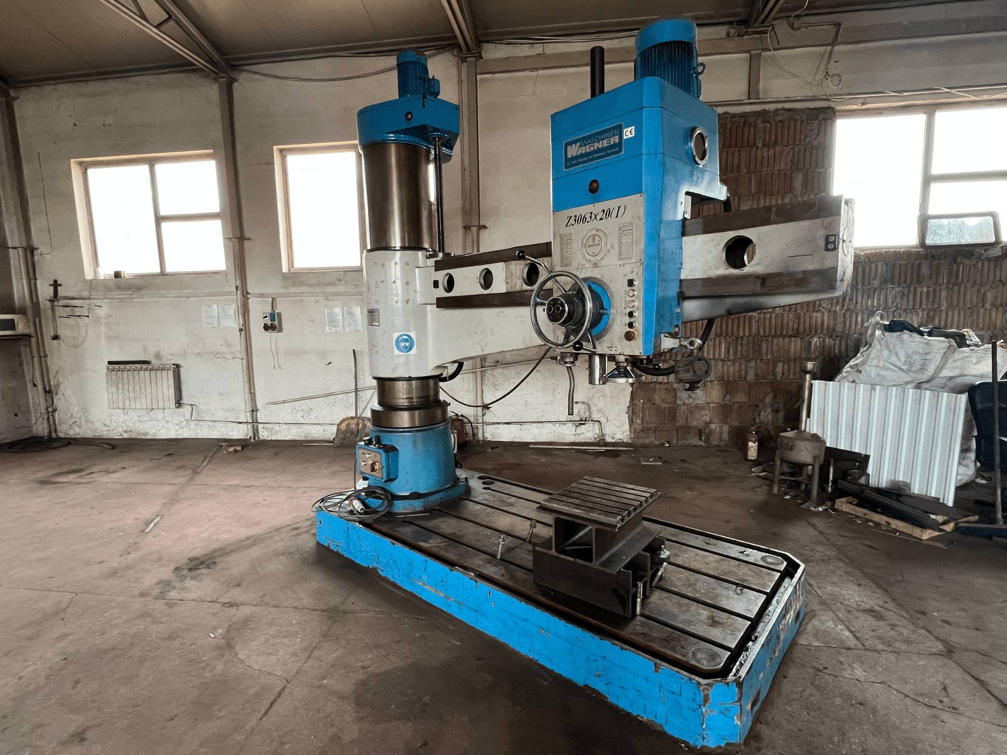 Foratrice Wagner Z3063x210 in un'officina, vista frontale; presenta un design blu e argento con base e tavolo di lavoro in metallo.