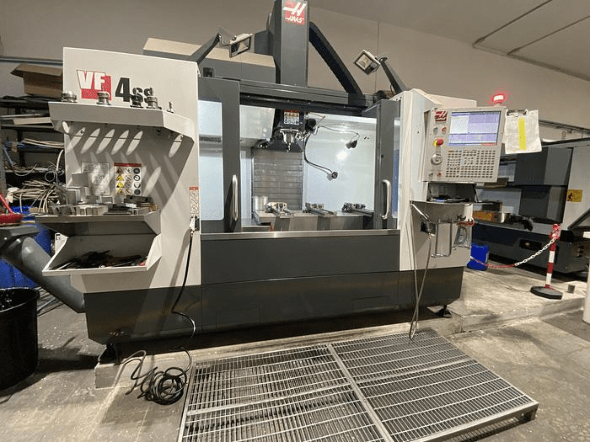 Fresatrice CNC Haas VF-4SS, vista frontale, con magazzino utensili, pannello di controllo e area di lavoro visibile in un'officina.