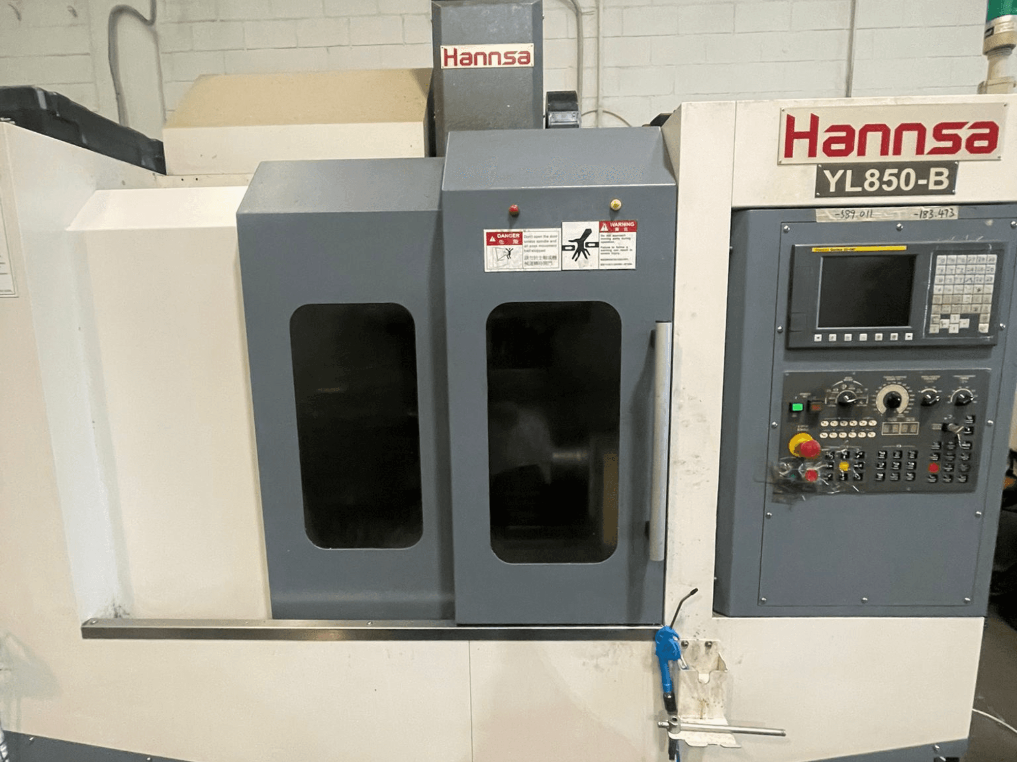 Centro di lavoro verticale HANNSA YL850-B, vista frontale, con pannello di controllo, pulsanti operativi e doppia finestra di osservazione.