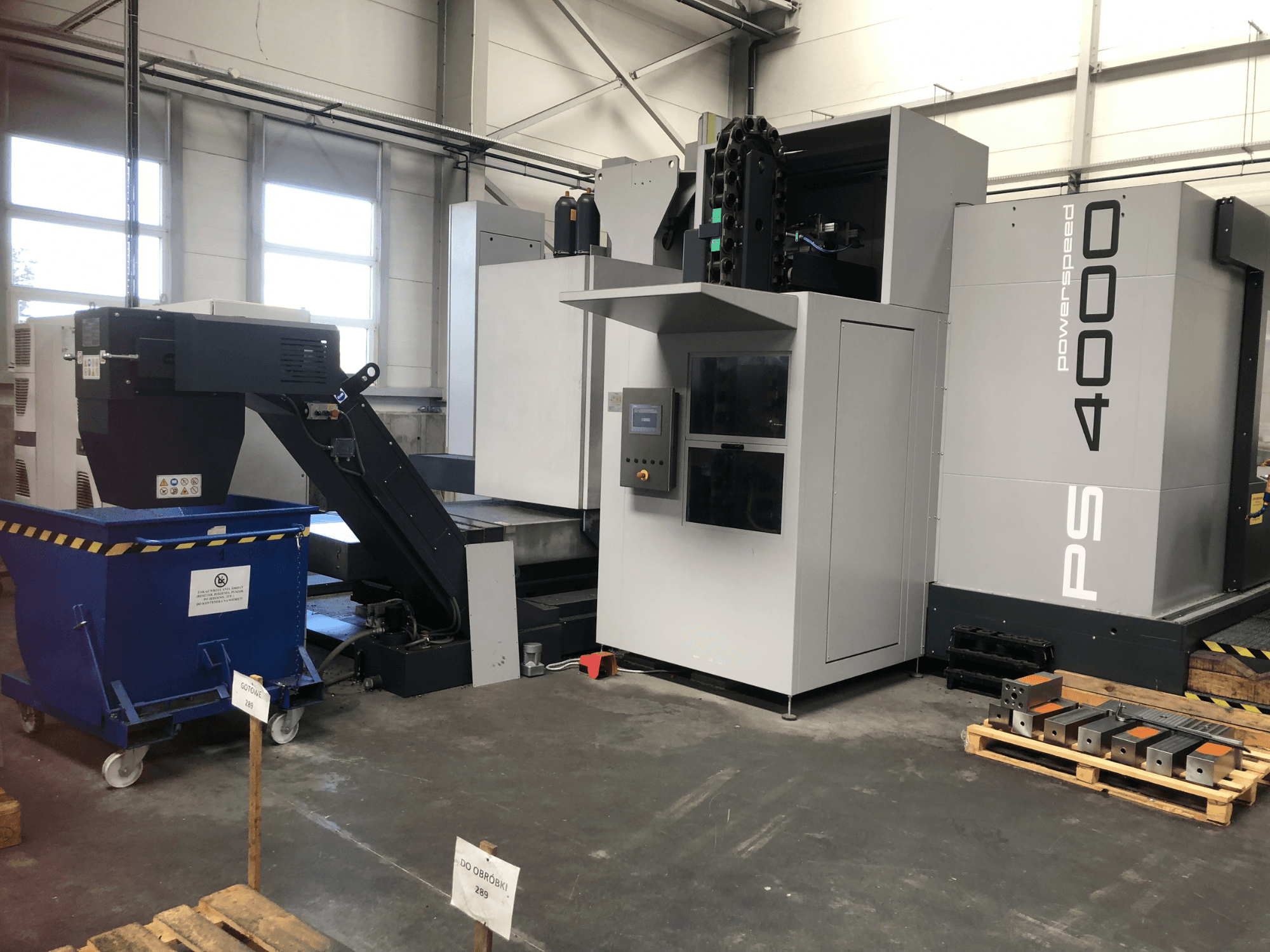 Centro di lavorazione orizzontale SHW PowerSpeed 4000 in un ambiente industriale, con in primo piano il pannello di controllo, il nastro trasportatore e i pezzi in lavorazione.