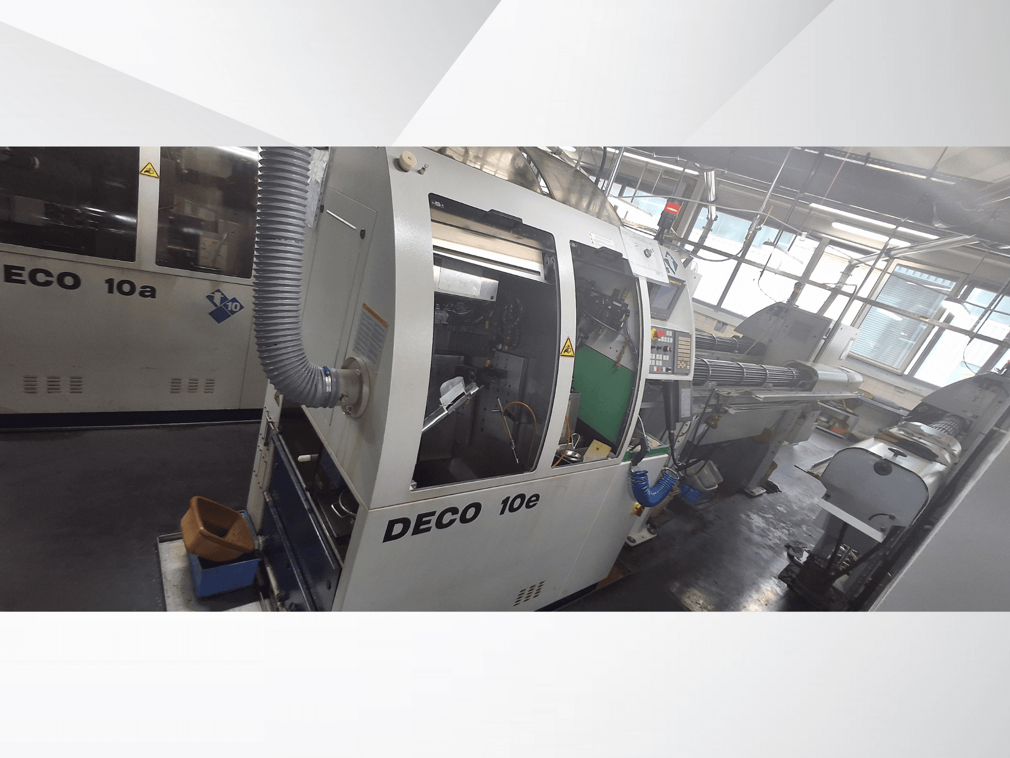 Macchina DECO 10e CNC in vista laterale, con pannello di controllo, interno verde e tubo di scarico collegato.