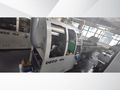 Macchina DECO 10e CNC in vista laterale, con pannello di controllo, interno verde e tubo di scarico collegato.