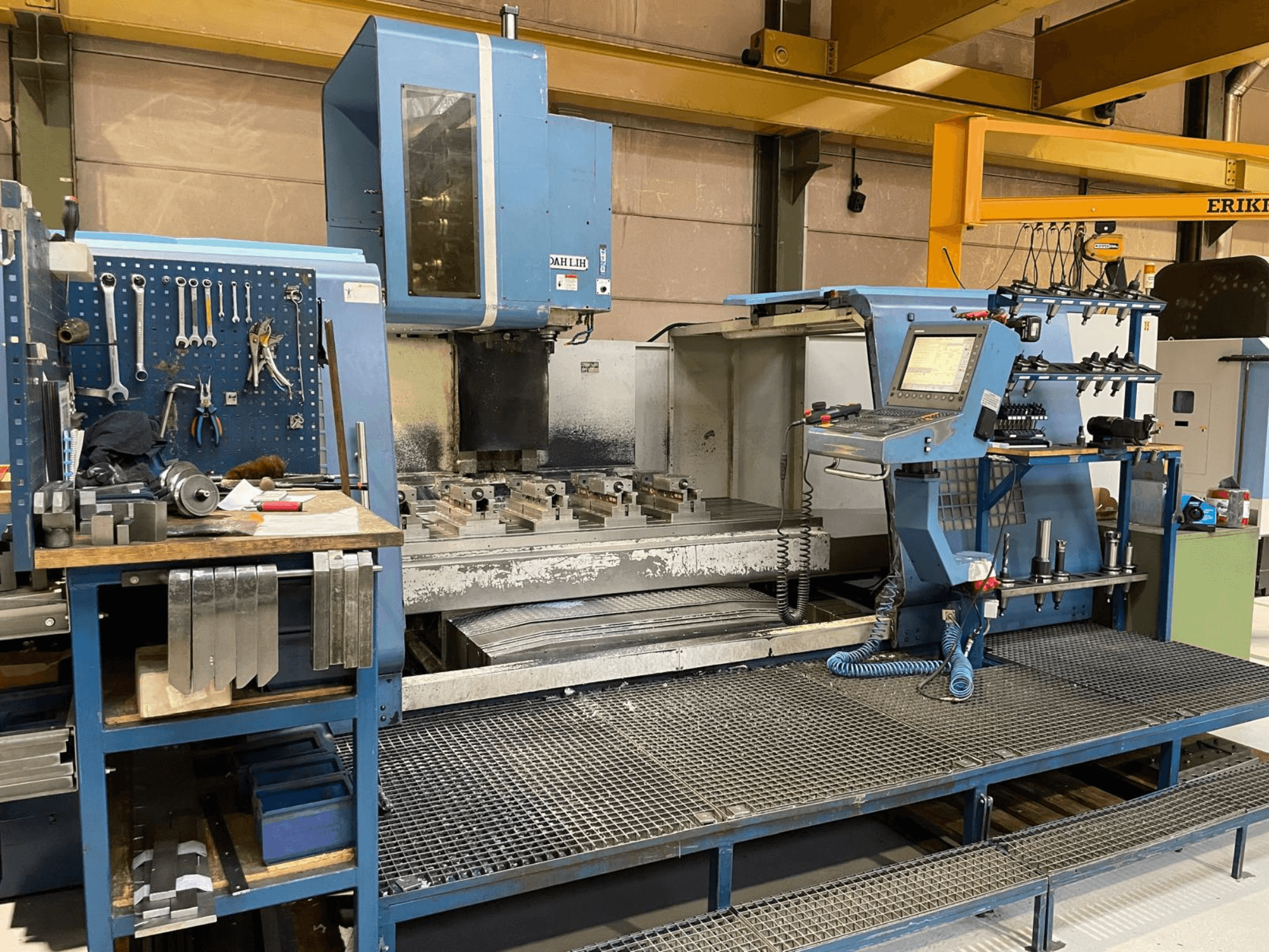 Centro di lavoro verticale DAH LIH MCV2600 vista frontale, che mostra il pannello di controllo, il tavolo di lavoro e l'area di stoccaggio degli utensili.