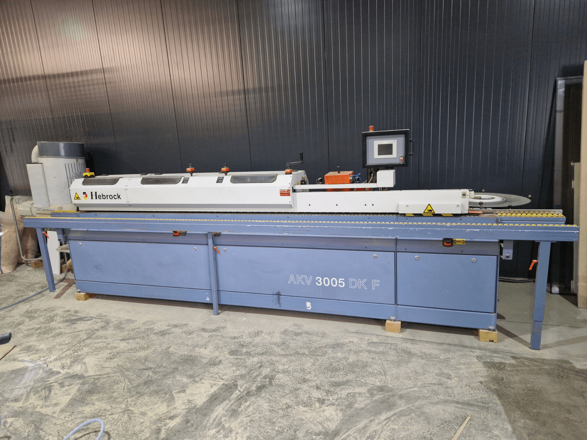 Bordatrice HEBROCK AKV 3005 DK-F, vista frontale, con pannello di controllo, nastro di alimentazione e impostazioni regolabili.