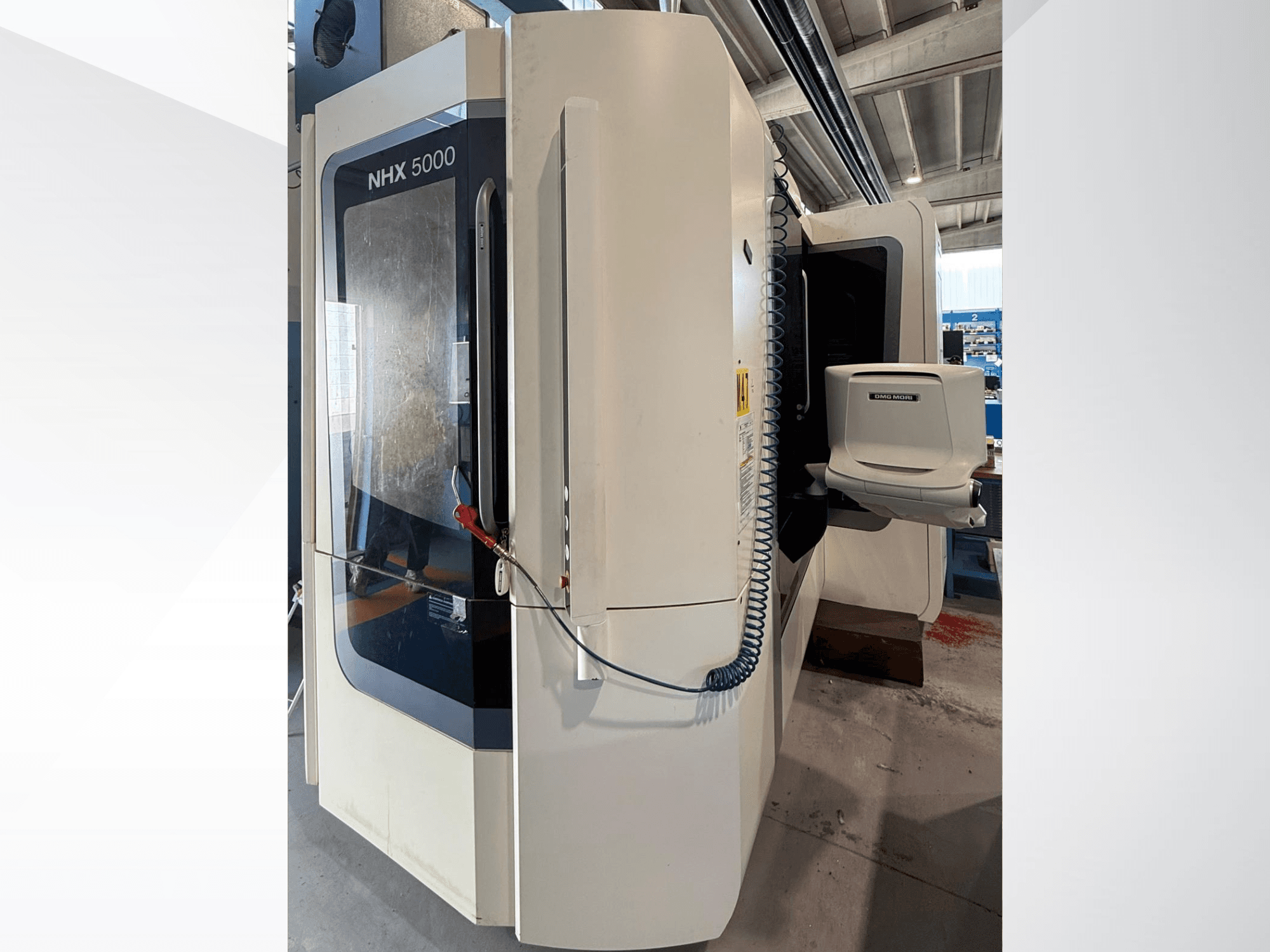Tornio orizzontale DMG MORI NHX 5000, vista frontale, con pannello di controllo e portamandrino in primo piano.