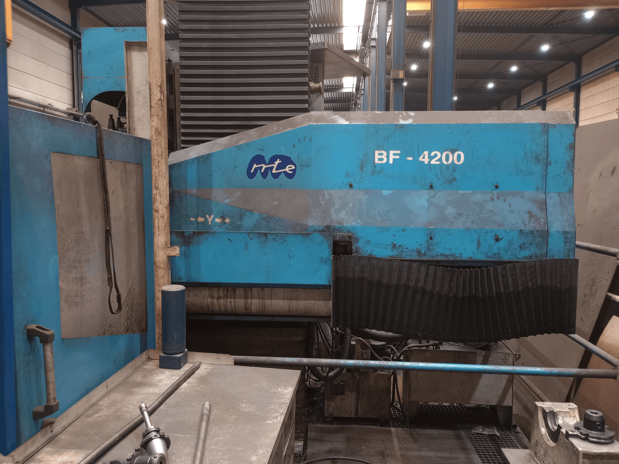 Fresatrice a bancale MTE BF 4200, vista laterale, che mostra l'esterno blu e i componenti della macchina in dettaglio in un ambiente di officina.