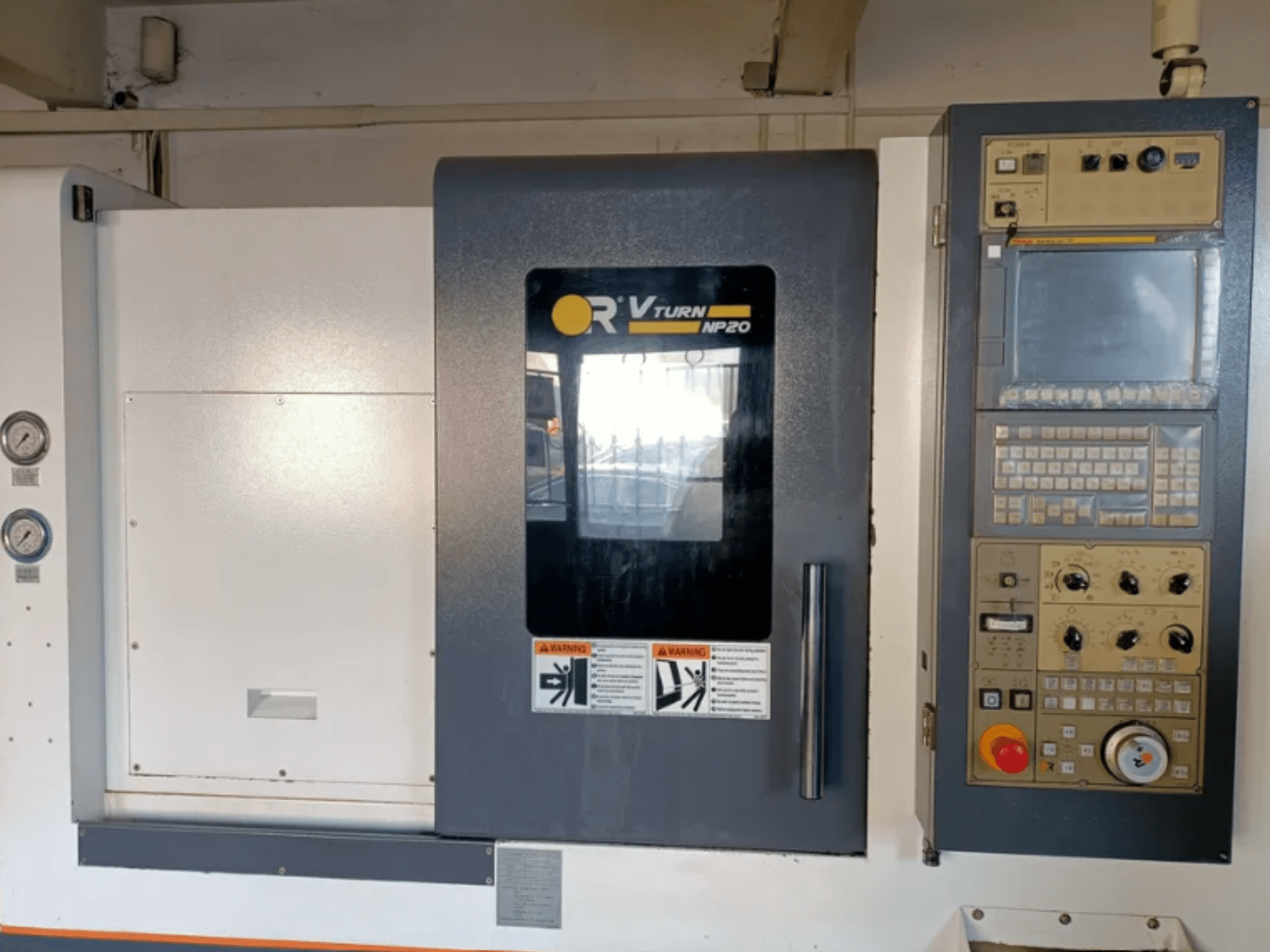 Vista frontale della macchina CNC OR VTURN NP20, con pannello di controllo con pulsanti, display e indicatori sul lato.