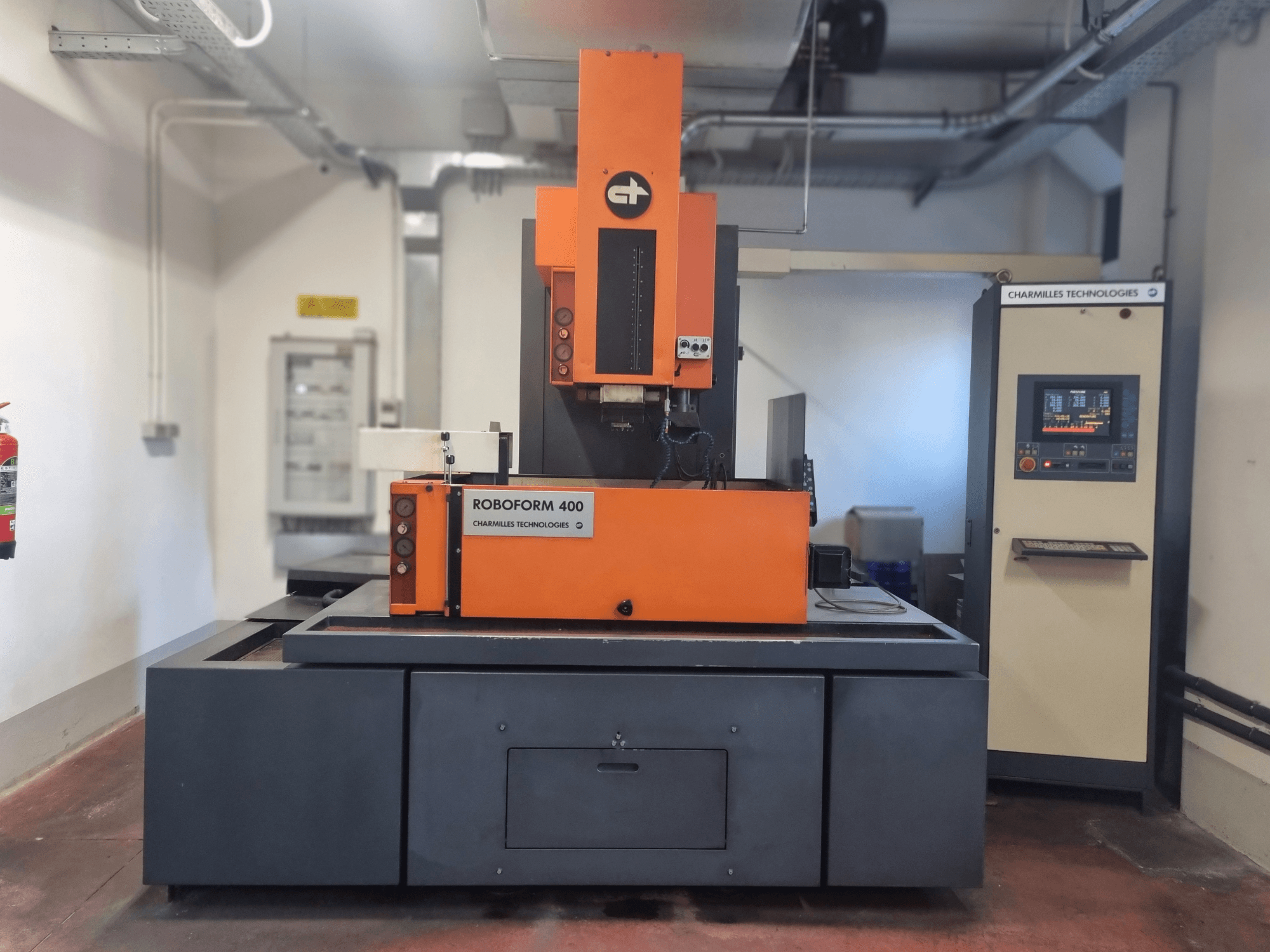 Macchina Roboforn 400 di Charmilles Technologies, vista frontale, con design arancione e grigio, pannello di controllo digitale visibile.