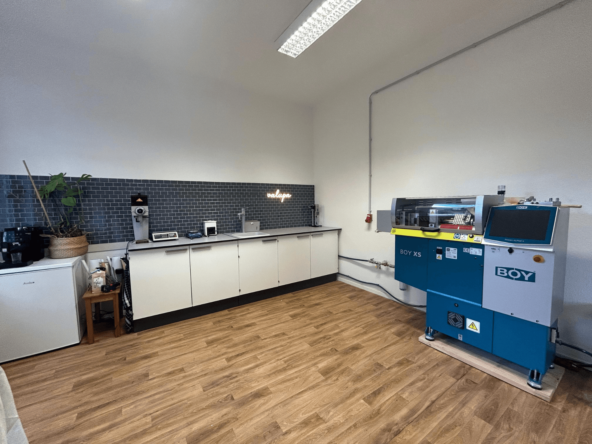 Pressa a iniezione idraulica BOY XS 161, vista frontale, in una cucina moderna con elettrodomestici e pavimento in legno.