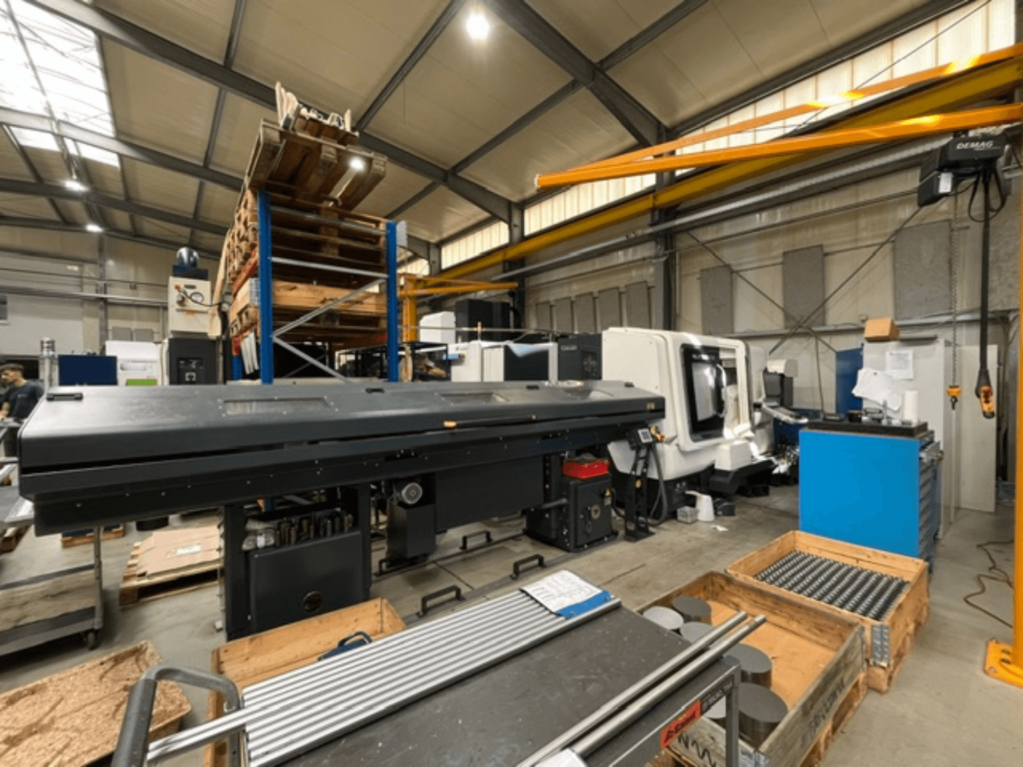 Tornio orizzontale DMG MORI MORI NLX 2500/700 SY in un ambiente di produzione, visto di lato, con utensili e pallet visibili.