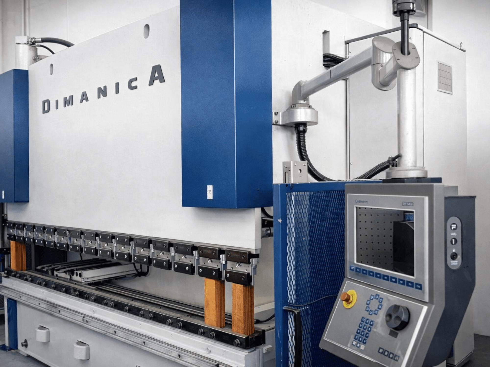 Pressa piegatrice DINAMICA 3000x100 di Warcom, vista laterale che mostra il pannello di controllo e gli strumenti di piegatura per la lavorazione dei metalli.