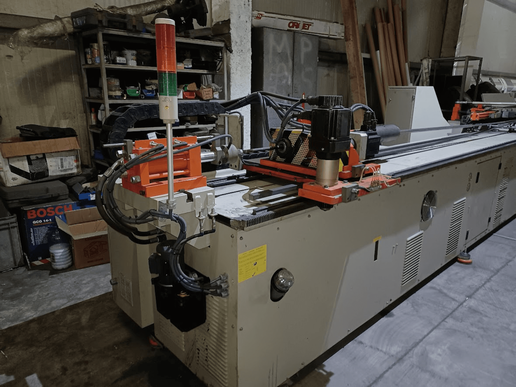 Piegatrice CANSA CNC 51 R1, vista laterale, che mostra il pannello di controllo, il motore e le spie luminose in un ambiente di officina.